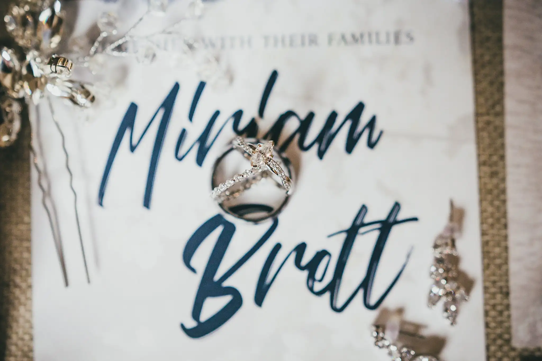 Barn at Harper Pines Wedding Thomaston, GA Atlanta Wedding Photographers Wedding Details: the wedding bands and a jeweled hairpin on the invitation, at a wedding at the Barn at Harper Pines in Thomaston, GA