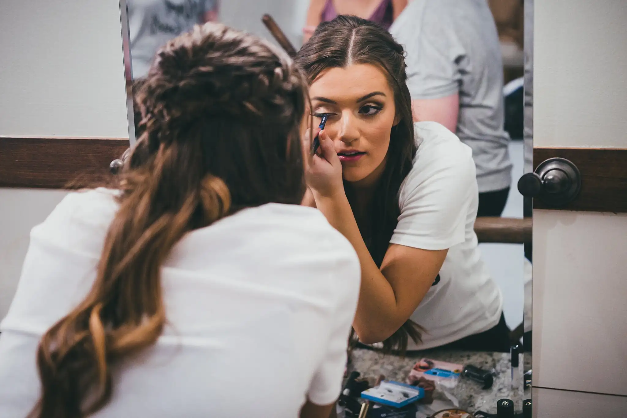 Barn at Harper Pines Wedding Thomaston, GA Atlanta Wedding Photographers Getting Ready: the bride having her makeup finished at the mirror, before their wedding at the Barn at Harper Pines in Thomaston, GA