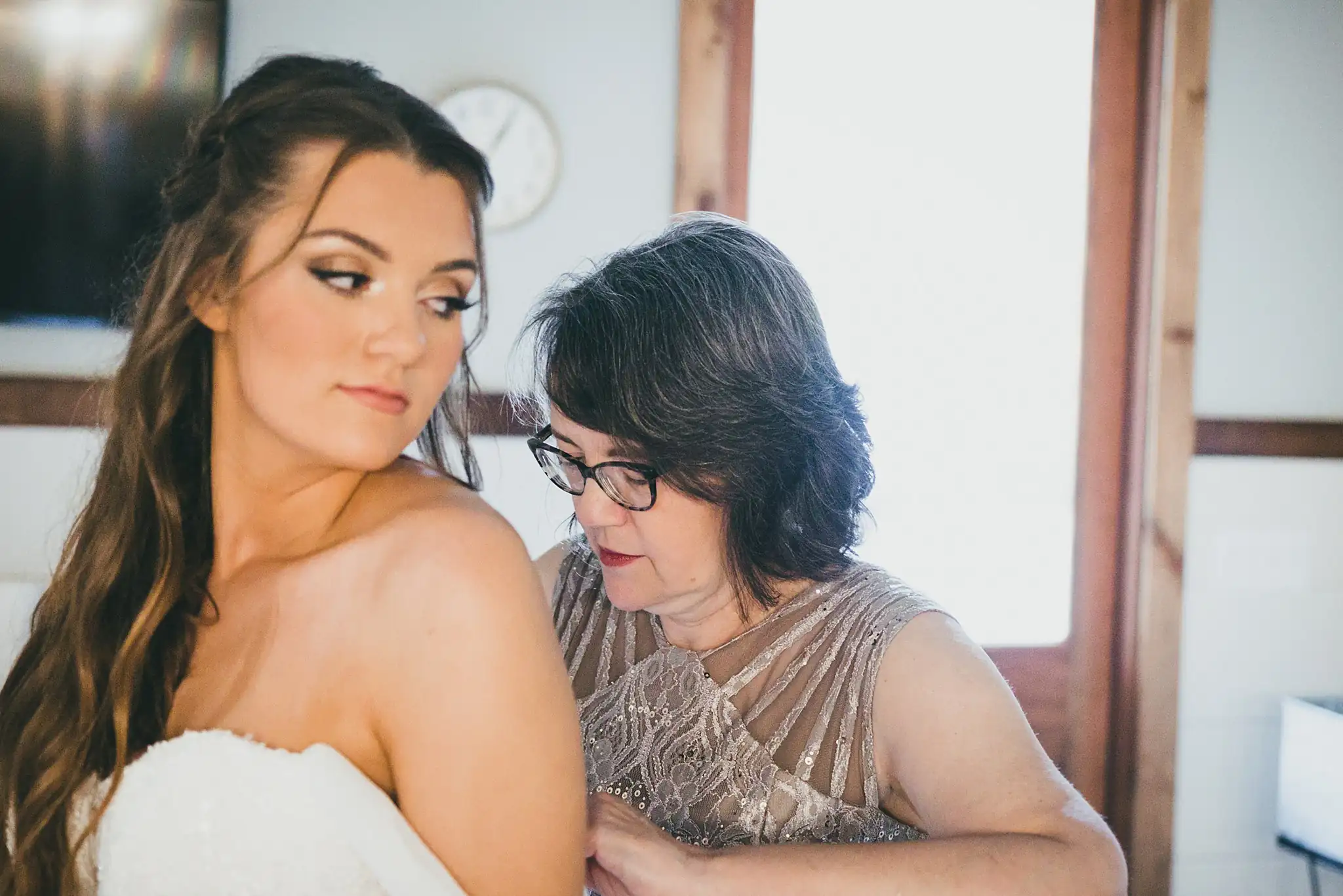 Barn at Harper Pines Wedding Thomaston, GA Atlanta Wedding Photographers Getting Ready: the bride's mother fastening her gown, before their wedding at the Barn at Harper Pines in Thomaston, GA