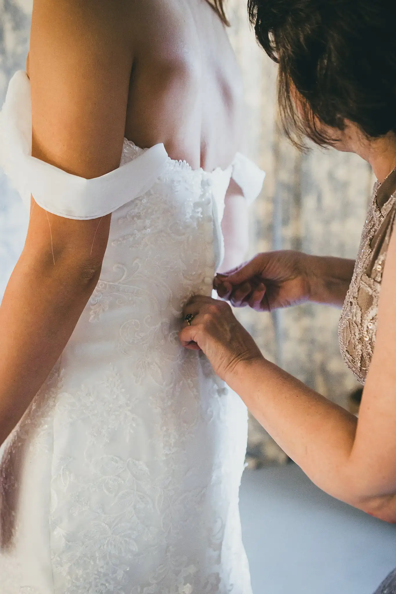 Barn at Harper Pines Wedding Thomaston, GA Atlanta Wedding Photographers Getting Ready: buttoning the back of the bride's lace gown, before their wedding at the Barn at Harper Pines in Thomaston, GA