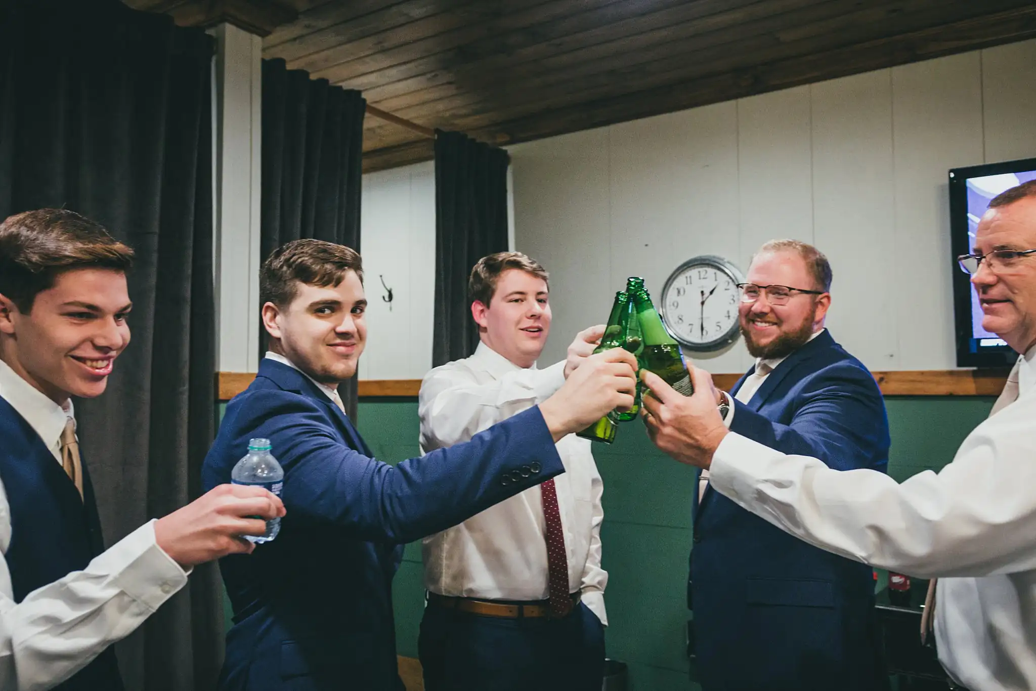 Barn at Harper Pines Wedding Thomaston, GA Atlanta Wedding Photographers Getting Ready: the groomsmen toasting with bottles, before their wedding at the Barn at Harper Pines in Thomaston, GA