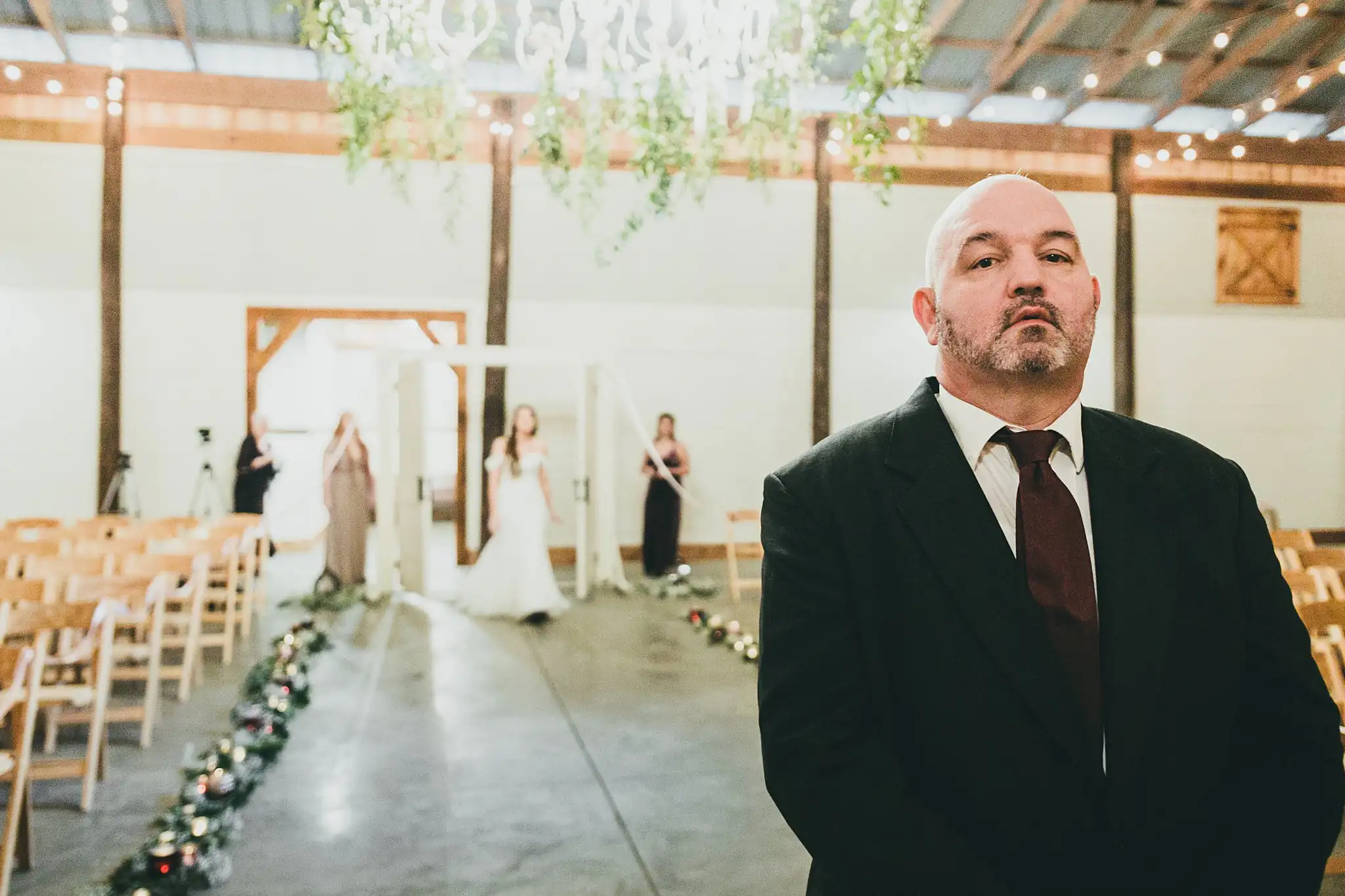 Barn at Harper Pines Wedding Thomaston, GA Atlanta Wedding Photographers Wedding Ceremony: the bride's father waiting by the lantern-lined aisle, at their wedding at the Barn at Harper Pines in Thomaston, GA