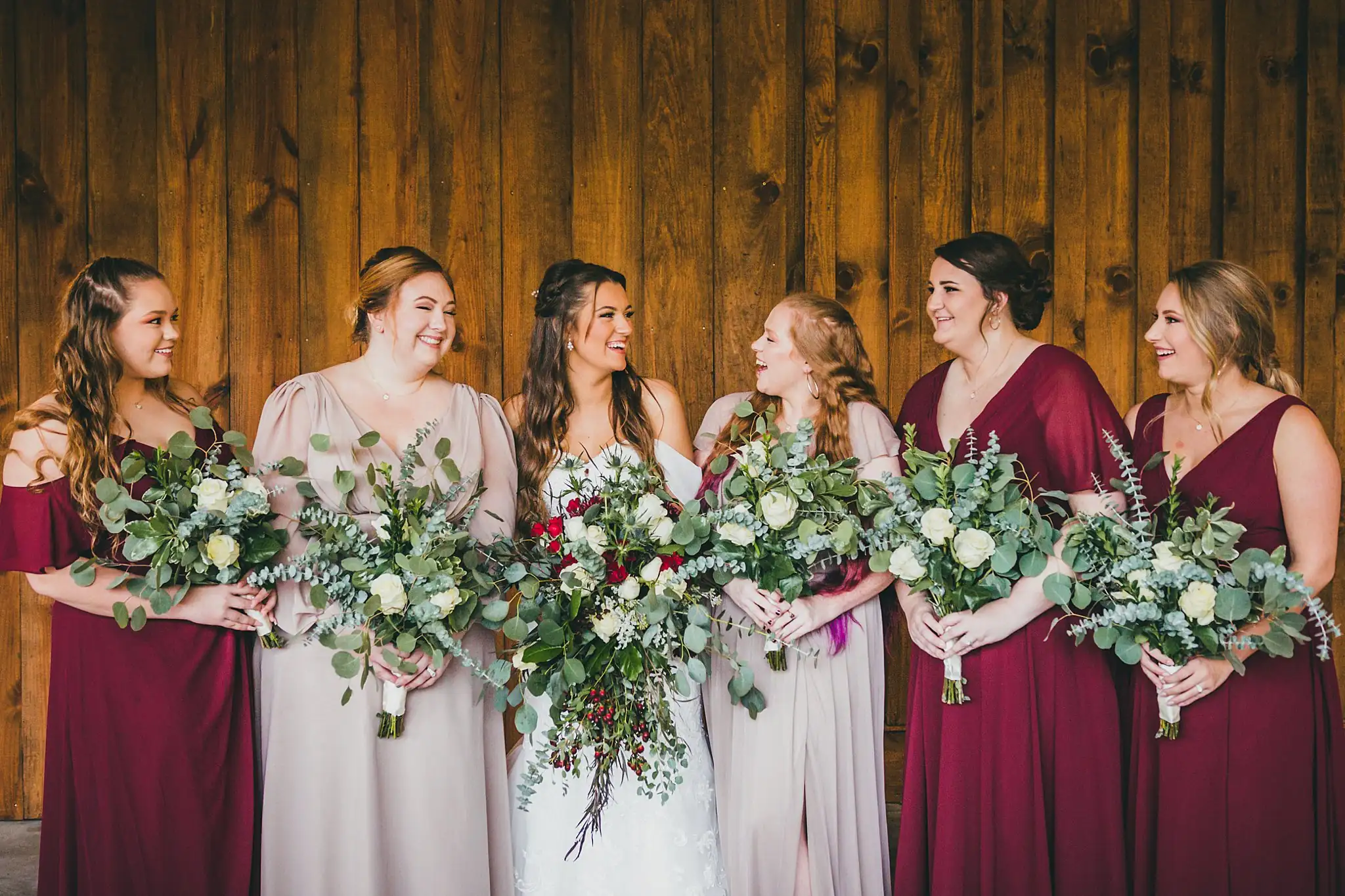 Barn at Harper Pines Wedding Thomaston, GA Atlanta Wedding Photographers Wedding Party: the bridesmaids in burgundy and blush with their bouquets, at their wedding at the Barn at Harper Pines in Thomaston, GA