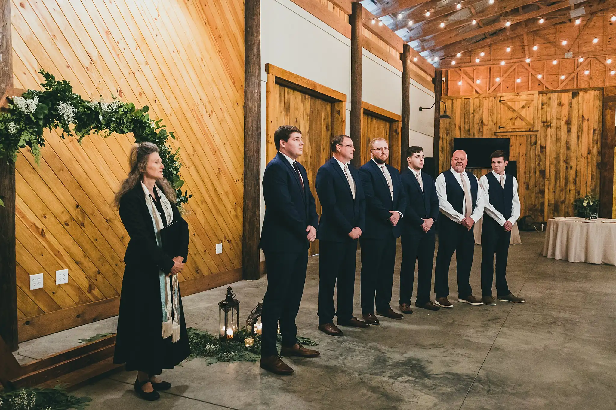 Barn at Harper Pines Wedding Thomaston, GA Atlanta Wedding Photographers Wedding Ceremony: the officiant and groomsmen waiting at the arch, at their wedding at the Barn at Harper Pines in Thomaston, GA