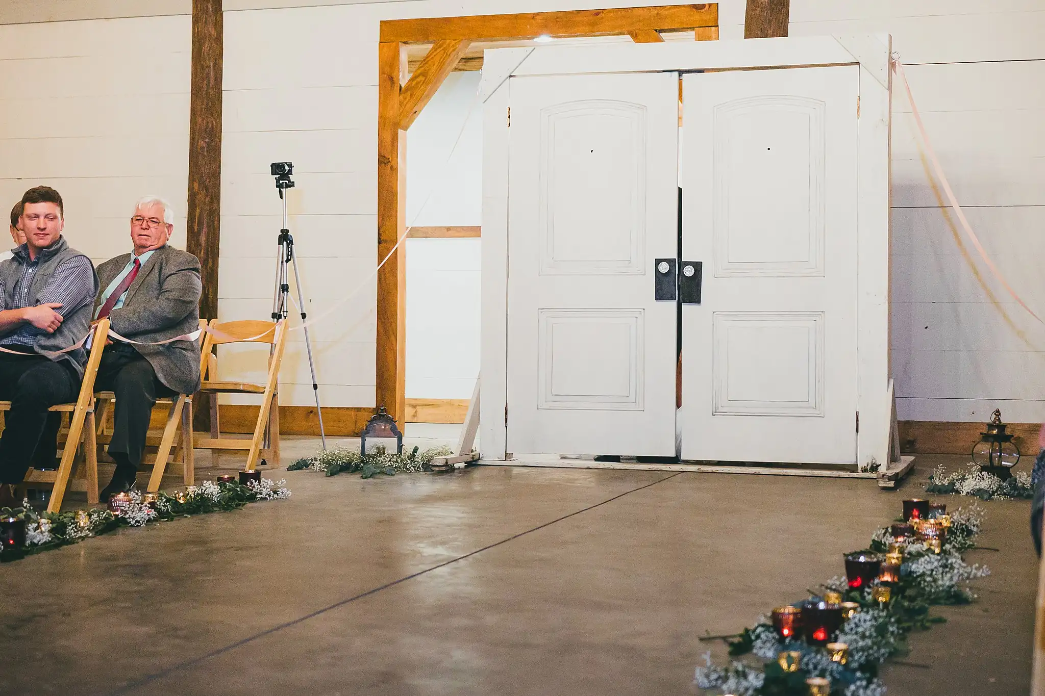 Barn at Harper Pines Wedding Thomaston, GA Atlanta Wedding Photographers Wedding Ceremony: the closed barn doors at the end of the candlelit aisle, at their wedding at the Barn at Harper Pines in Thomaston, GA