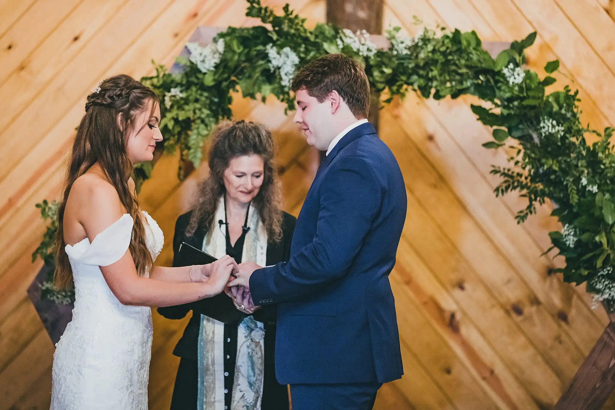Barn at Harper Pines Wedding Thomaston, GA Atlanta Wedding Photographers Wedding Ceremony: the bride putting on the groom's ring, at their wedding at the Barn at Harper Pines in Thomaston, GA