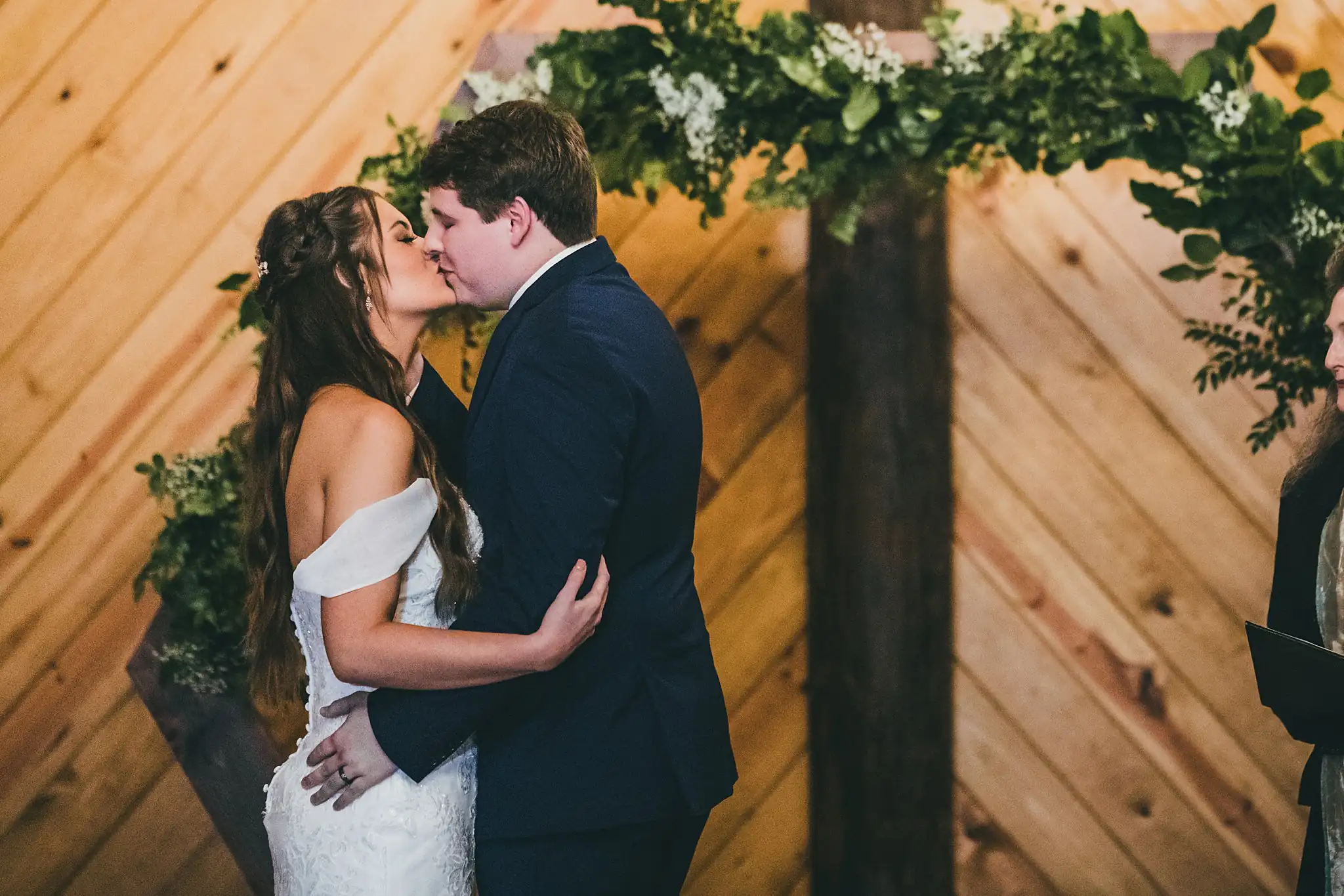 Barn at Harper Pines Wedding Thomaston, GA Atlanta Wedding Photographers Wedding Ceremony: the first kiss beneath the greenery arch, at their wedding at the Barn at Harper Pines in Thomaston, GA