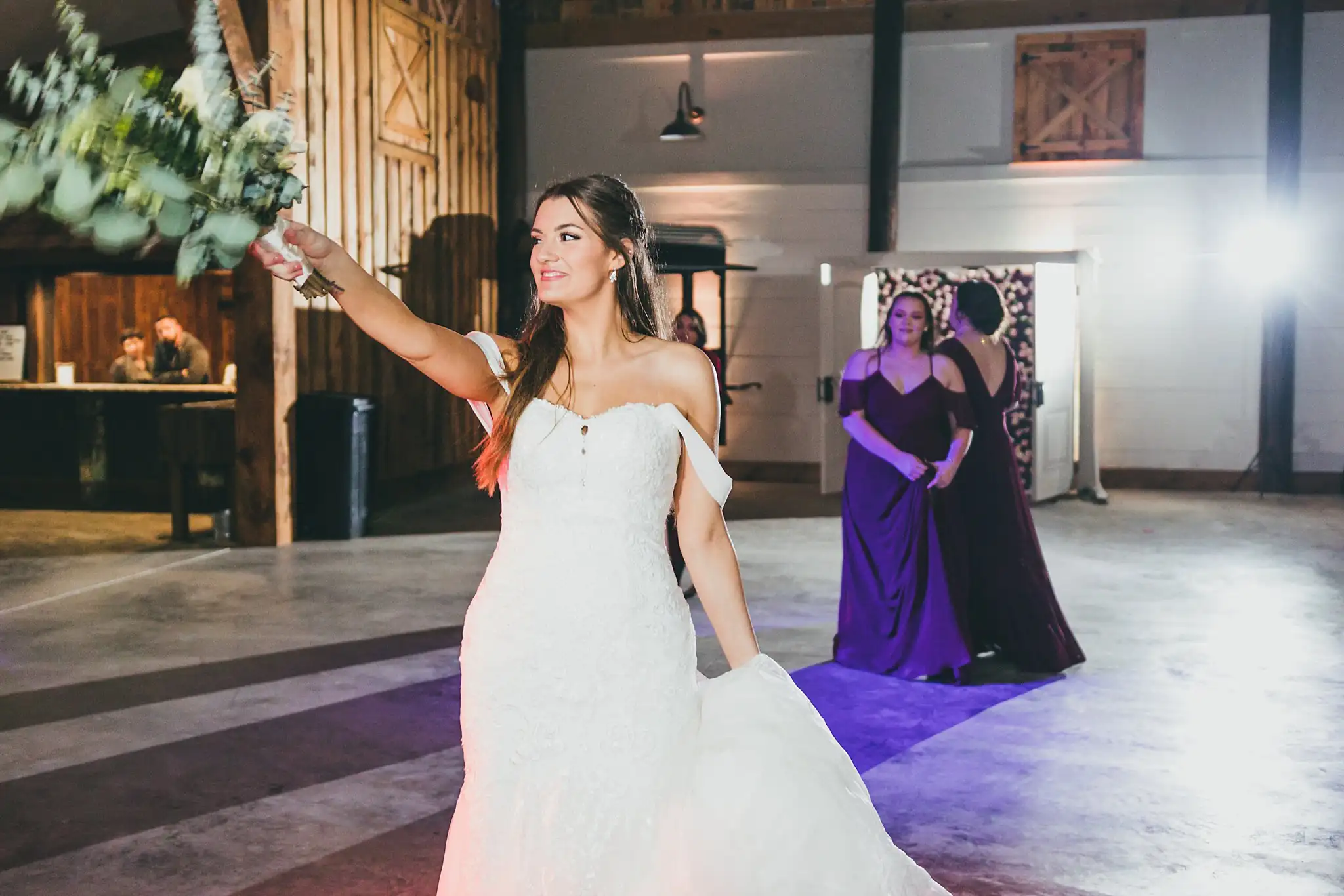Barn at Harper Pines Wedding Thomaston, GA Atlanta Wedding Photographers Bouquet Toss: the bride raising her bouquet, at their wedding at the Barn at Harper Pines in Thomaston, GA