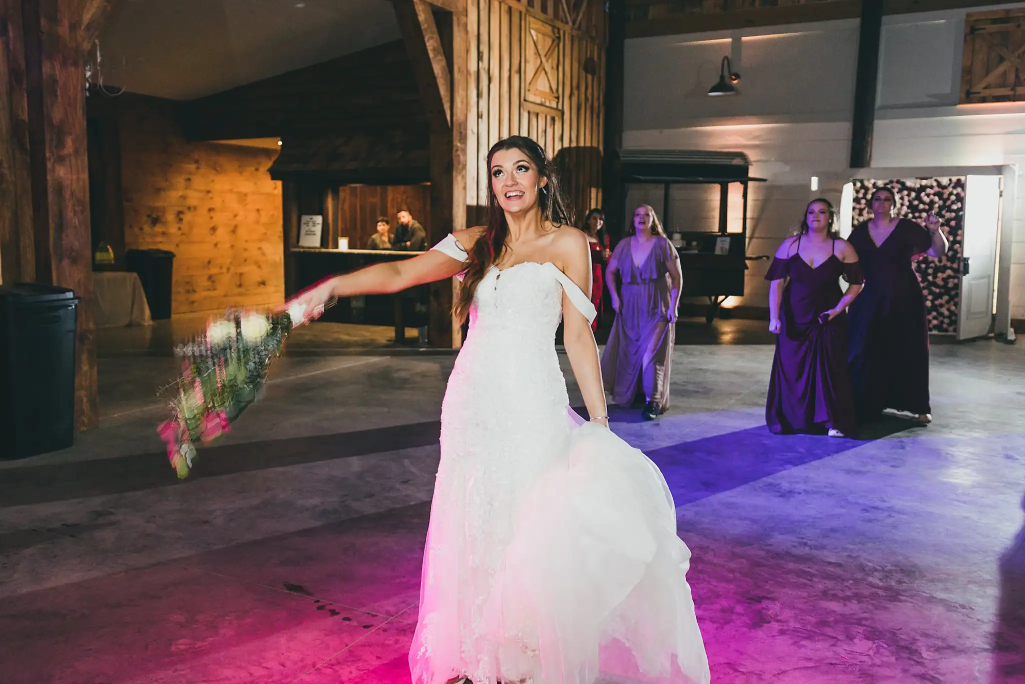 Barn at Harper Pines Wedding Thomaston, GA Atlanta Wedding Photographers Bouquet Toss: the bride about to throw her bouquet, at their wedding at the Barn at Harper Pines in Thomaston, GA