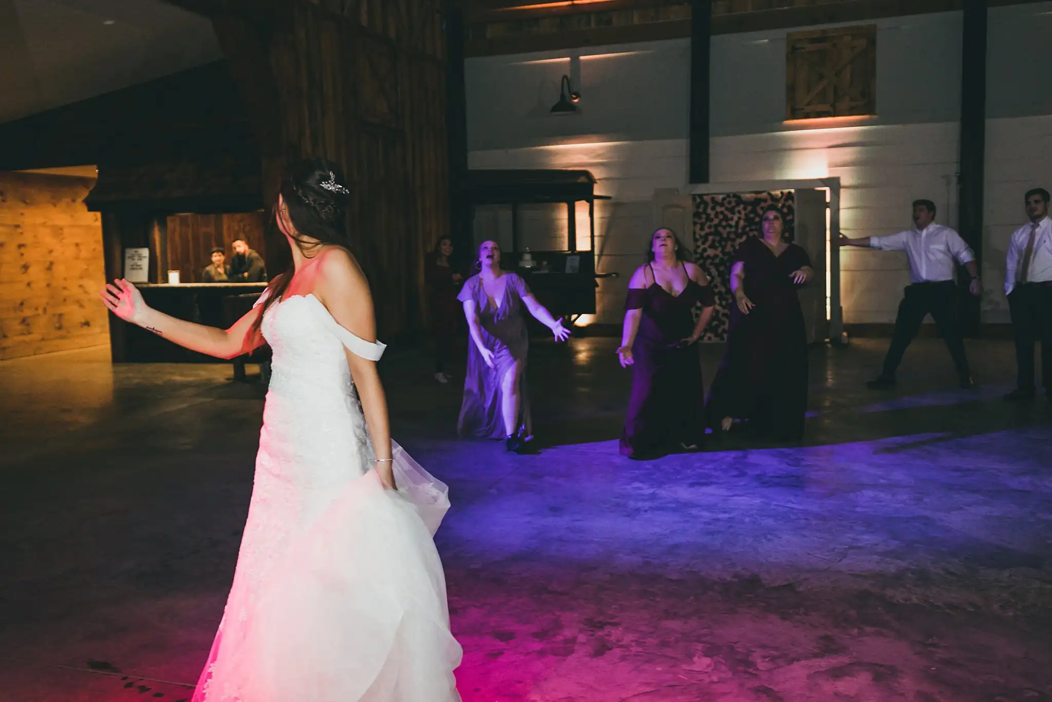 Barn at Harper Pines Wedding Thomaston, GA Atlanta Wedding Photographers Bouquet Toss: the guests waiting behind the bride, at their wedding at the Barn at Harper Pines in Thomaston, GA