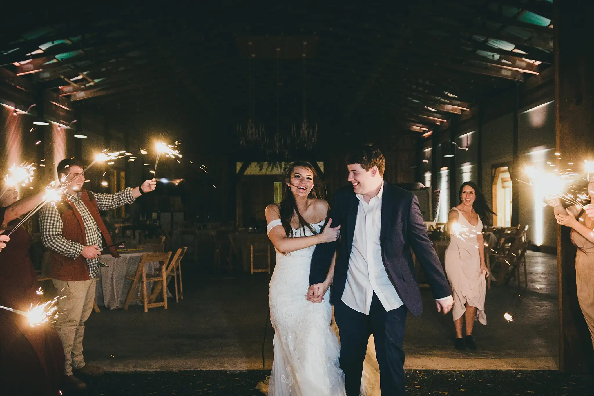 Barn at Harper Pines Wedding Thomaston, GA Atlanta Wedding Photographers Sparkler Exit: the couple heading out through the sparklers, at their wedding at the Barn at Harper Pines in Thomaston, GA