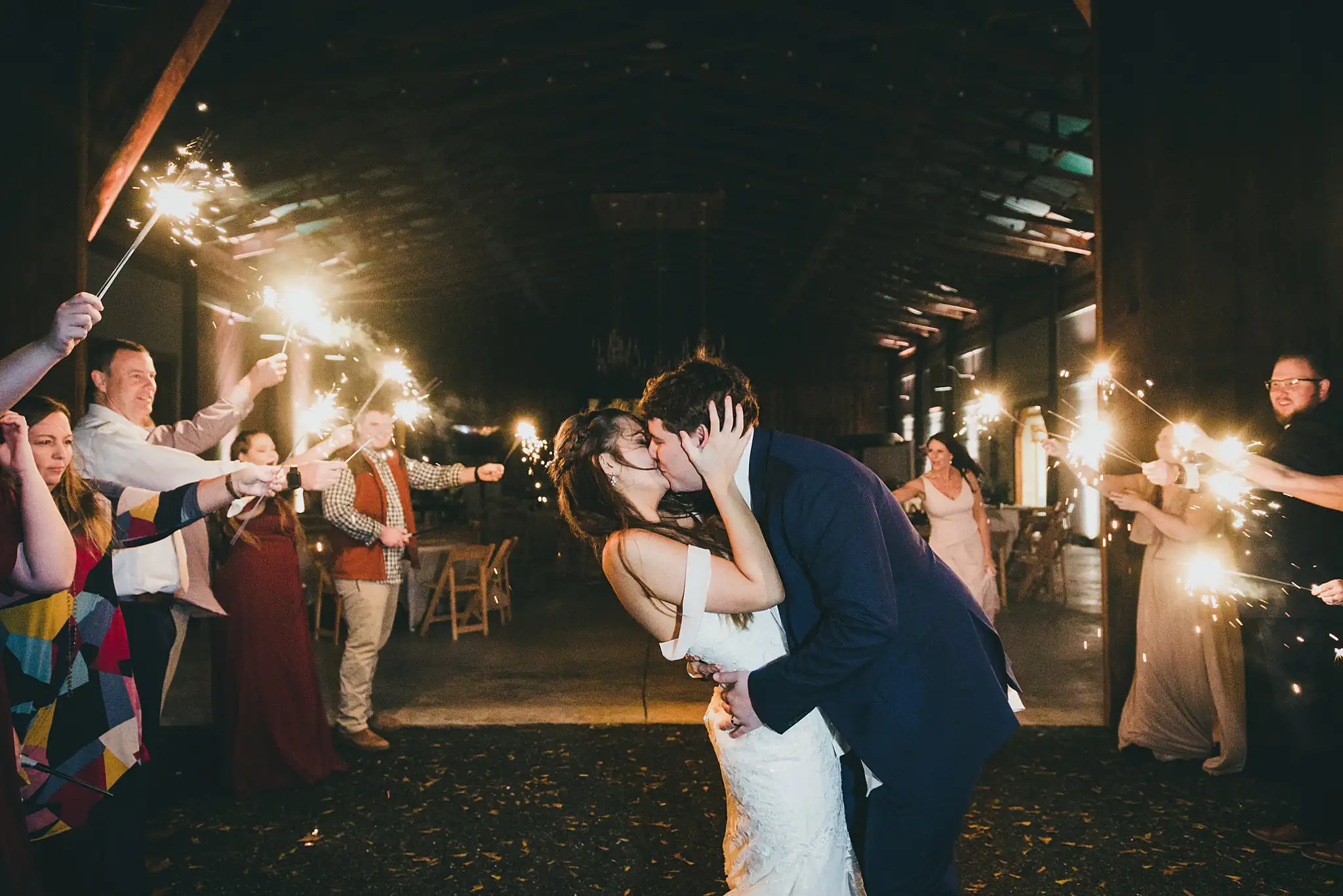 Barn at Harper Pines Wedding Thomaston, GA Atlanta Wedding Photographers Sparkler Exit: the couple kissing among the sparklers, at their wedding at the Barn at Harper Pines in Thomaston, GA