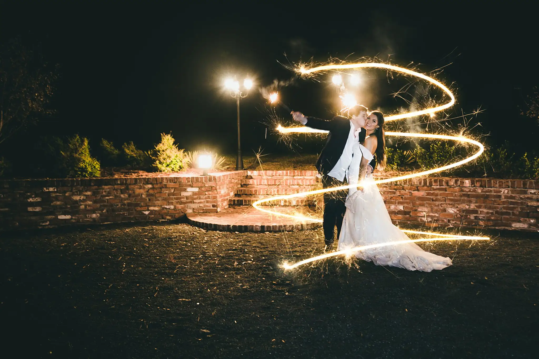 Barn at Harper Pines Wedding Thomaston, GA Atlanta Wedding Photographers Wedding Formals: a spiral of sparkler light around the couple, at their wedding at the Barn at Harper Pines in Thomaston, GA
