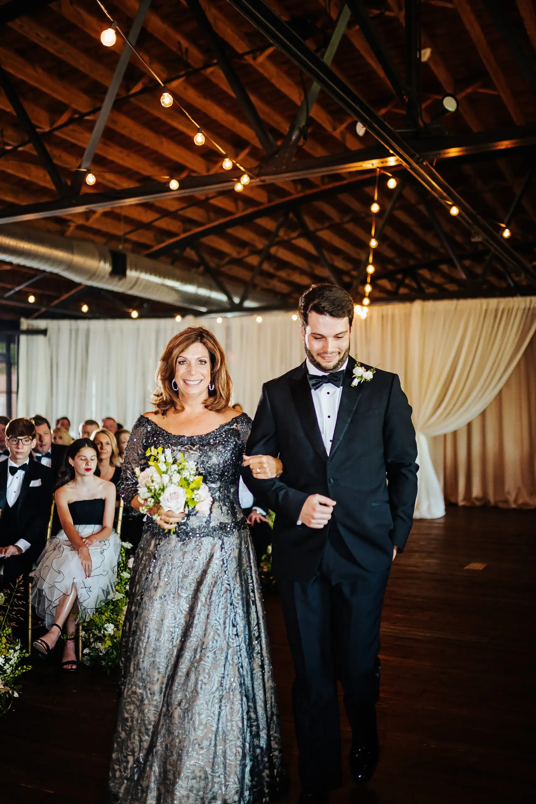Processional: the groom walking his mother down the aisle, at their wedding at Summerour Studio in Atlanta, GA
