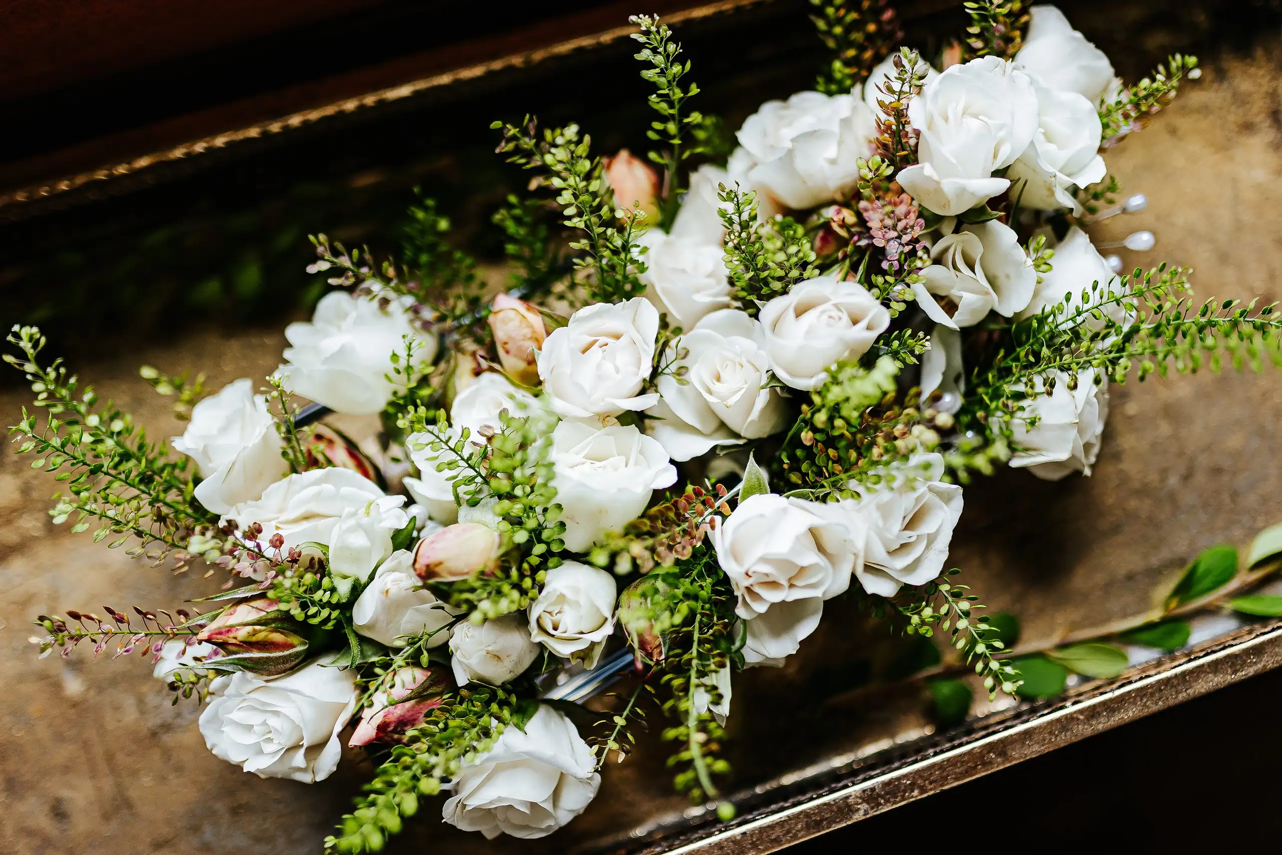 Wedding Florals: white roses and greenery in a garland, at a wedding at Summerour Studio in Atlanta, GA