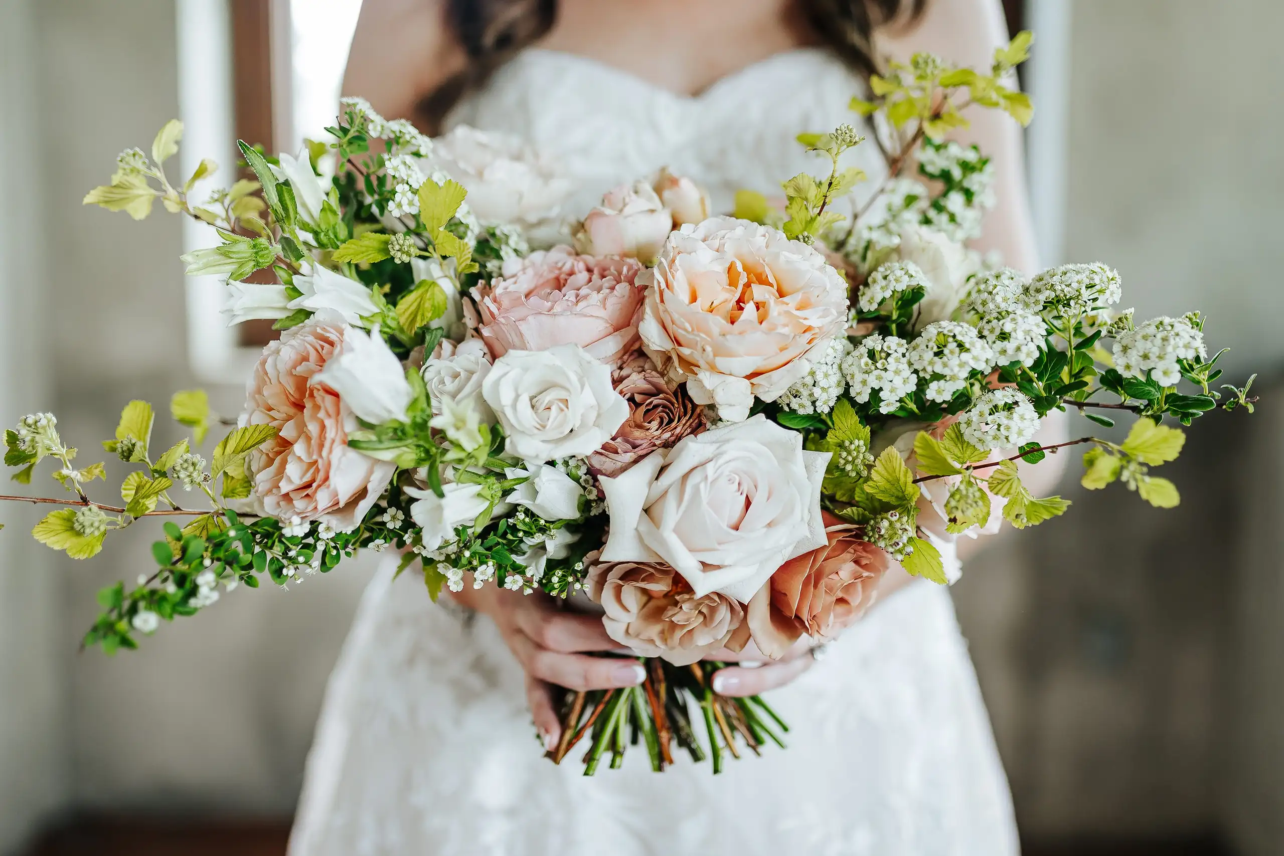Wedding Florals: the bride holding her blush and cream garden rose bouquet, at a wedding at Summerour Studio in Atlanta, GA