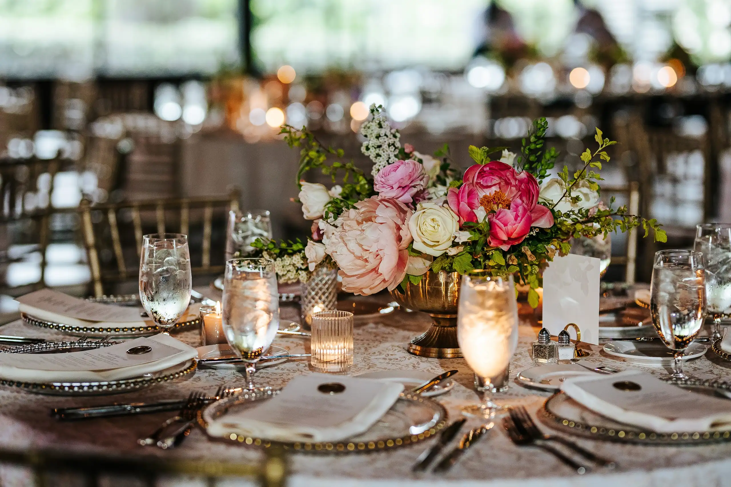 Reception Details: place settings with gold chargers and spring flowers, at a wedding at Summerour Studio in Atlanta, GA