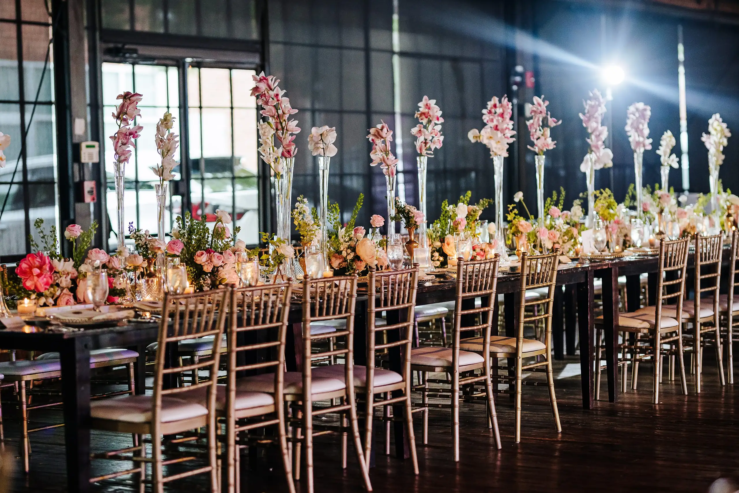Reception Details: the long table set with tall flowers and gold chairs, at a wedding at Summerour Studio in Atlanta, GA