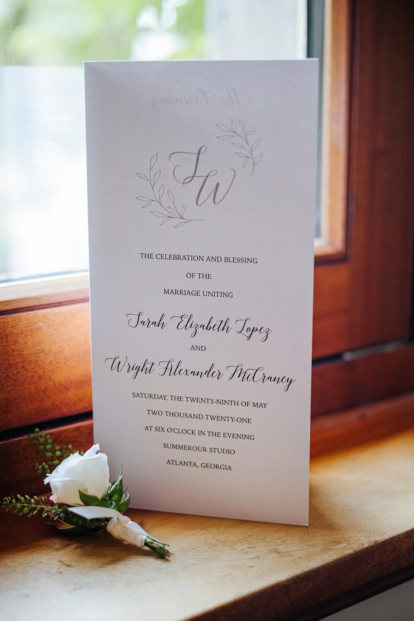 Wedding Details: the program and a boutonniere on the windowsill, at a wedding at Summerour Studio in Atlanta, GA