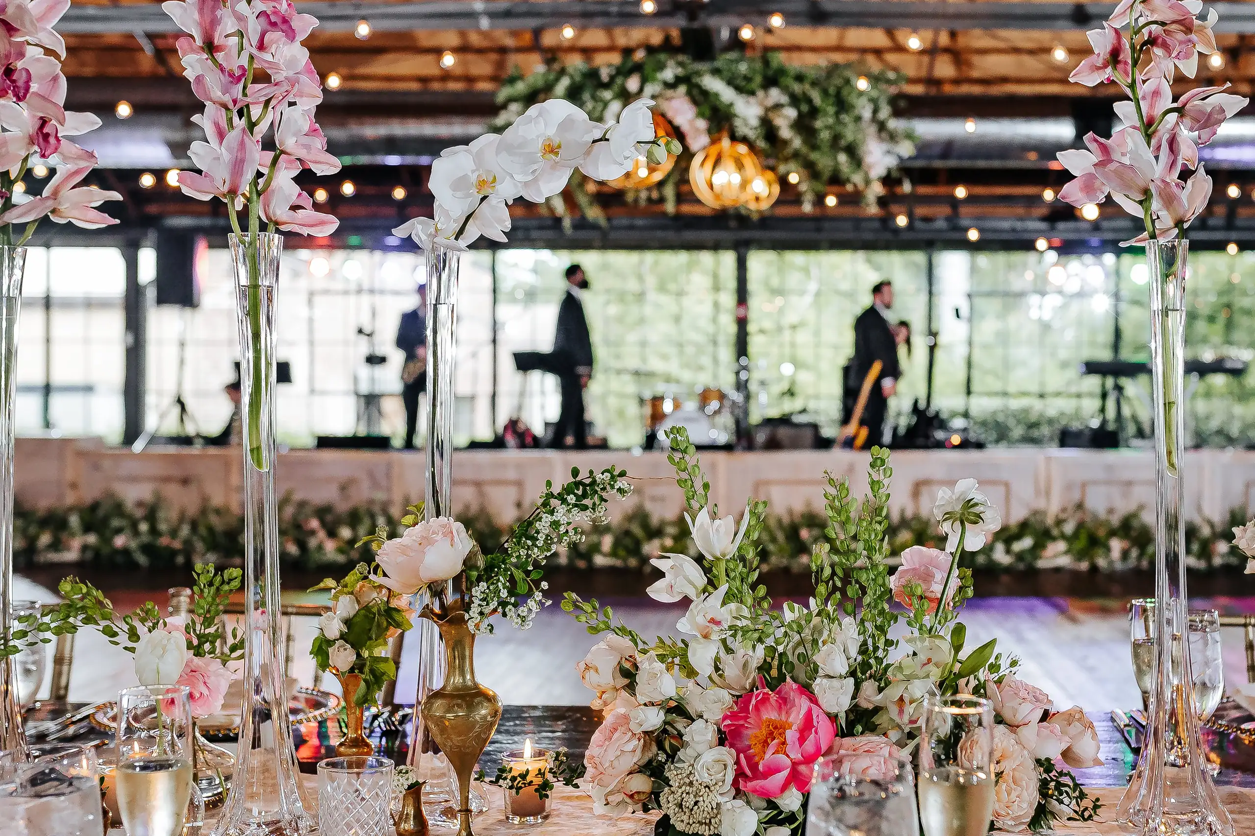 Reception Details: the band's stage seen past the table flowers, at a wedding at Summerour Studio in Atlanta, GA