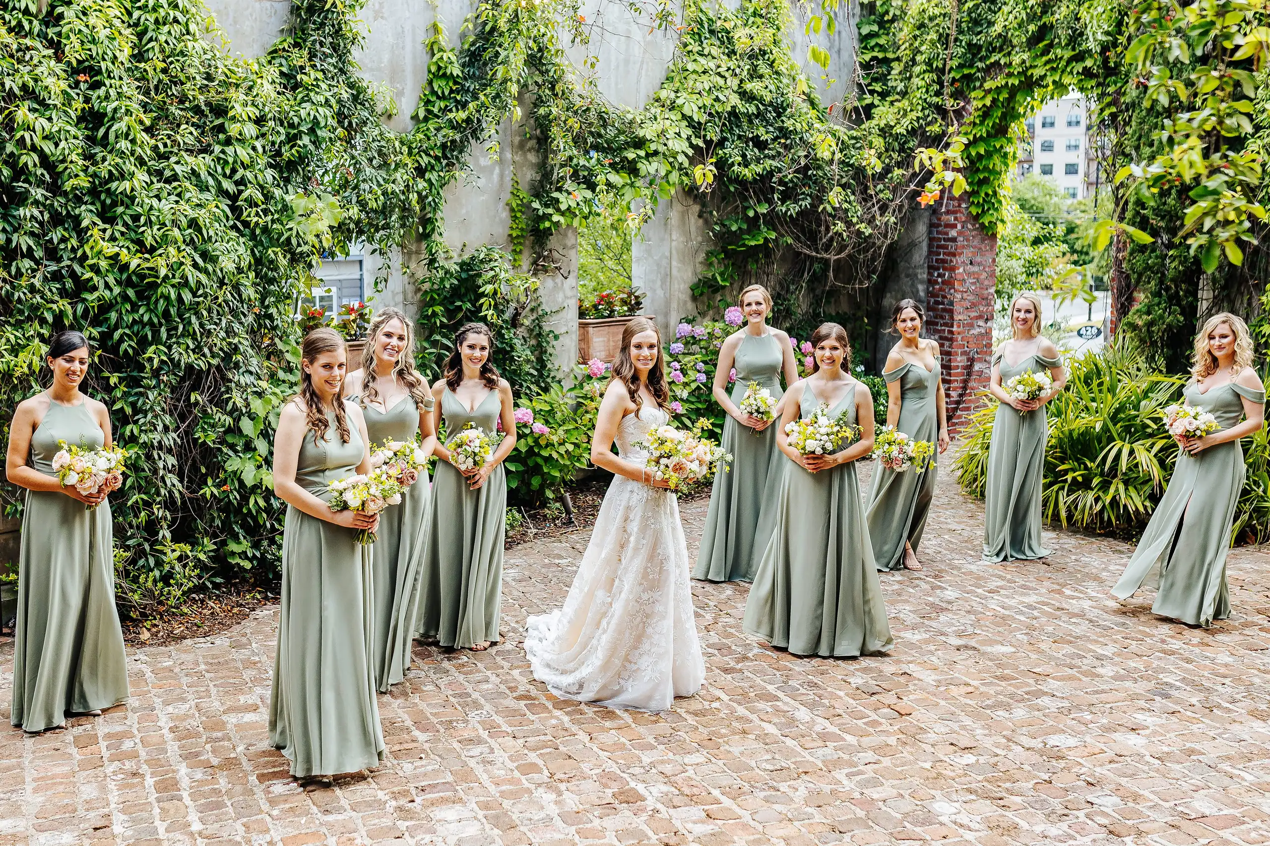 Wedding Party: the bride with her bridesmaids on the brick courtyard, at their wedding at Summerour Studio in Atlanta, GA