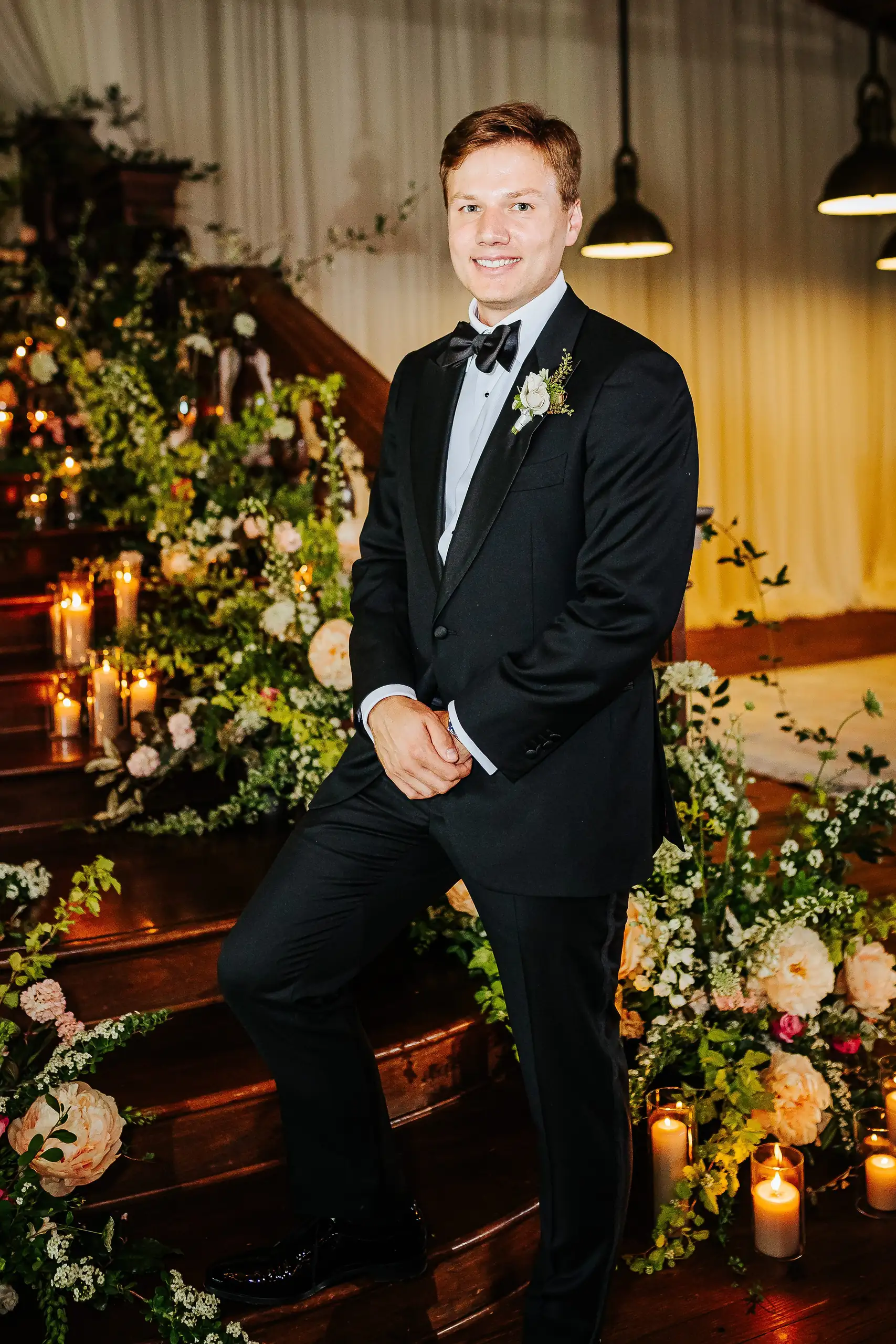 Wedding Formals: the groom on the flower-covered staircase, at their wedding at Summerour Studio in Atlanta, GA