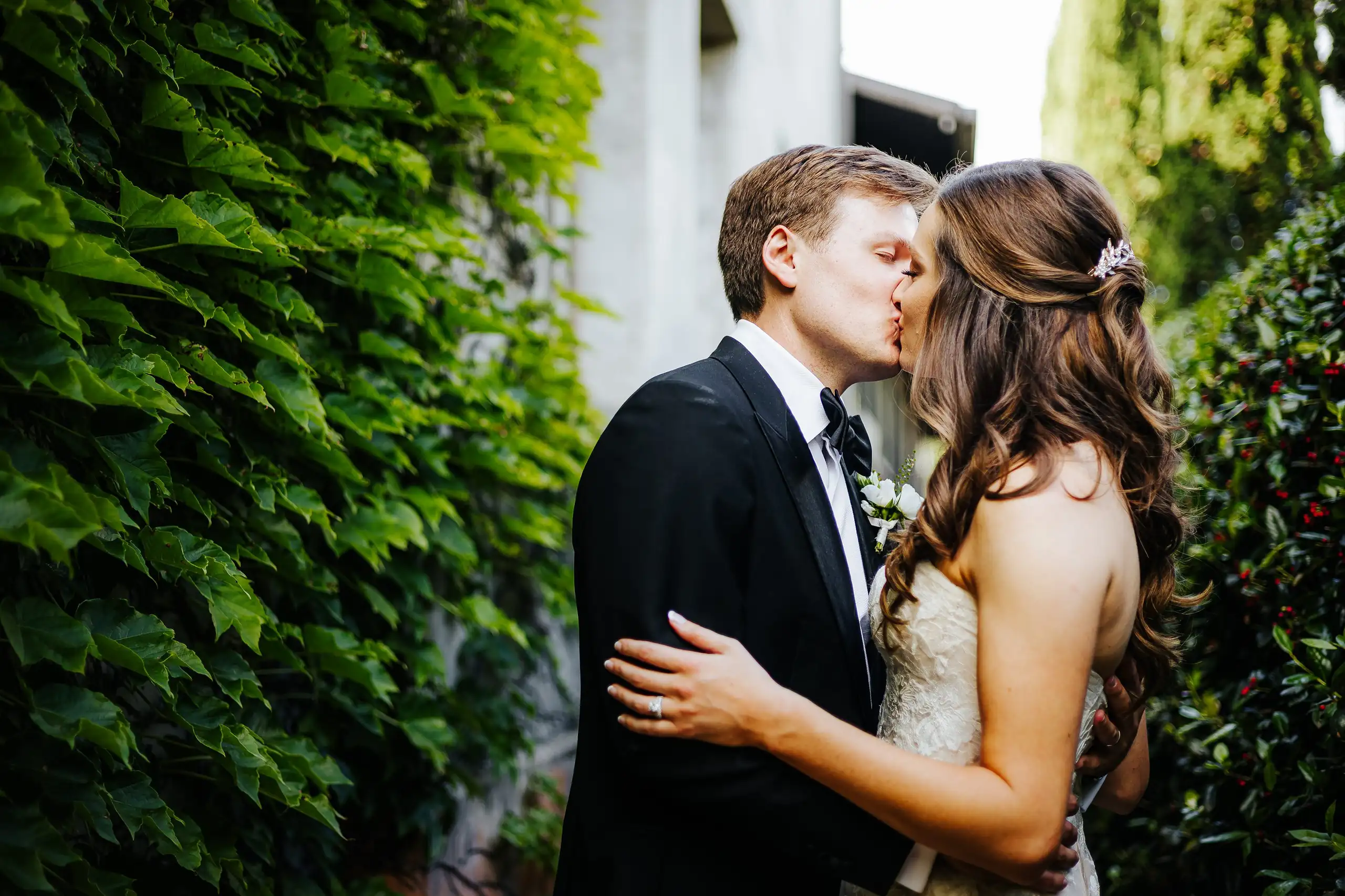 Wedding Formals: the couple kissing against the ivy wall, at their wedding at Summerour Studio in Atlanta, GA