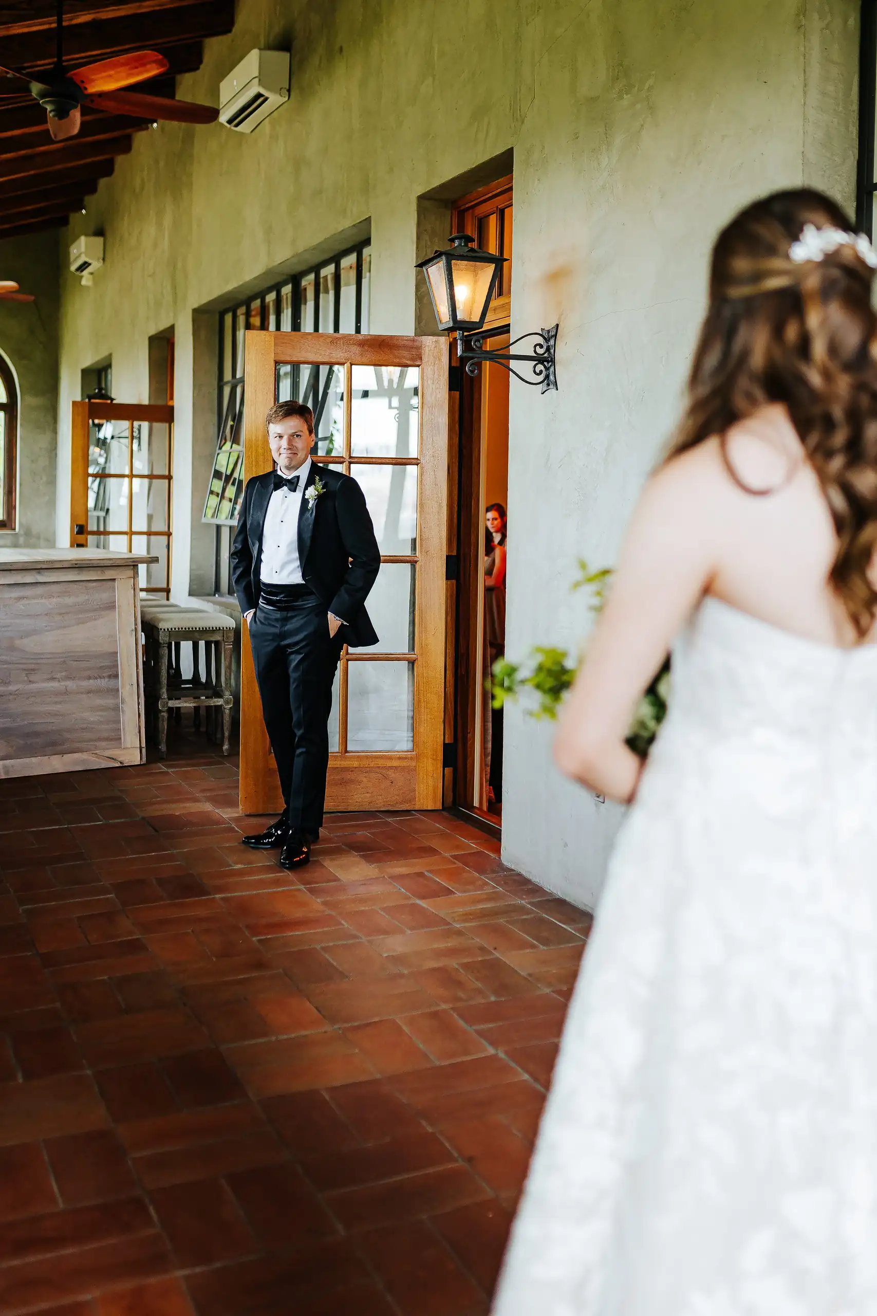 First Look: the groom waiting in the corridor as the bride comes to him, before their wedding at Summerour Studio in Atlanta, GA