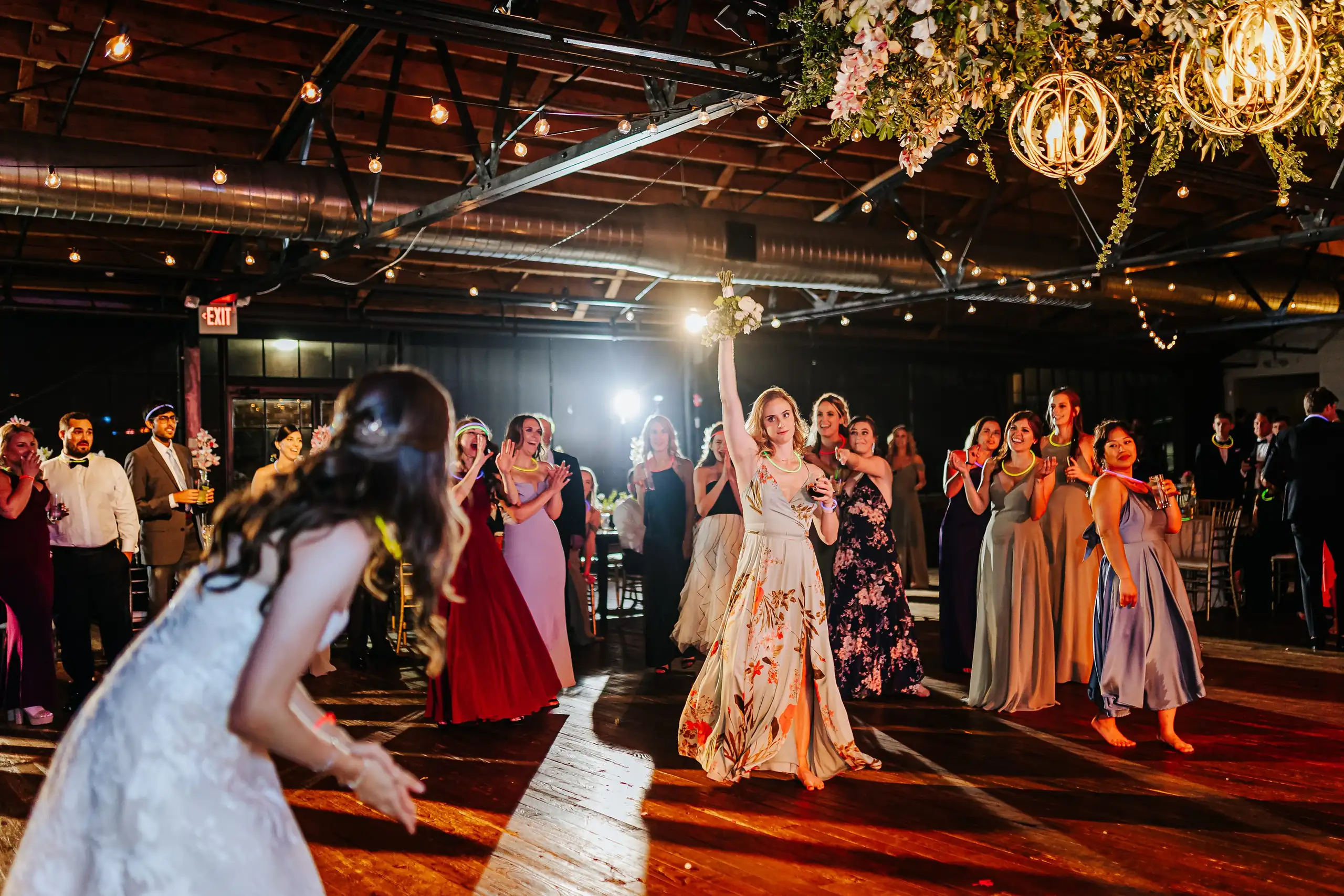 Bouquet Toss: the bride throwing her bouquet, at their wedding at Summerour Studio in Atlanta, GA