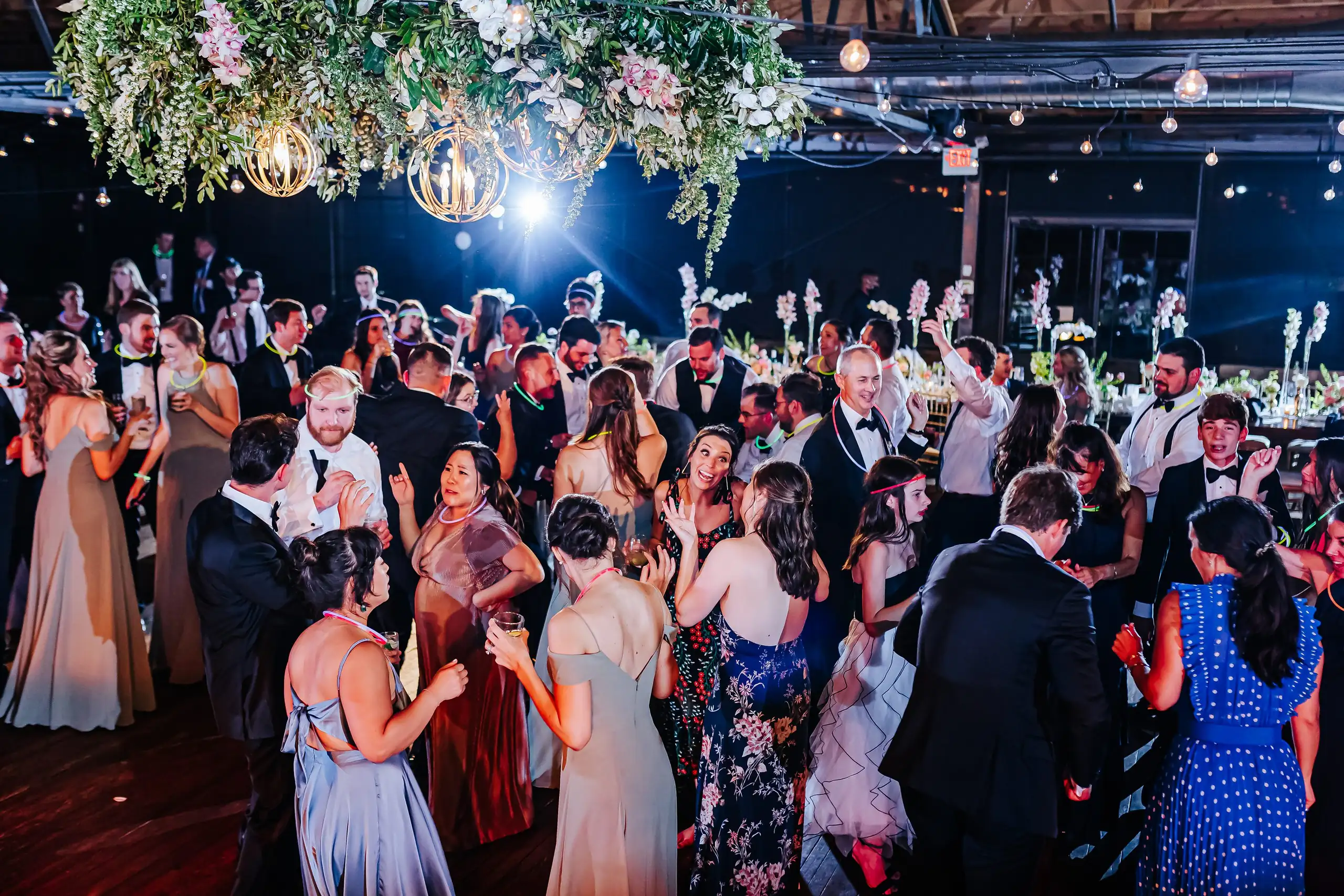 Wedding Reception: the dance floor full under the hanging flowers, at their wedding at Summerour Studio in Atlanta, GA