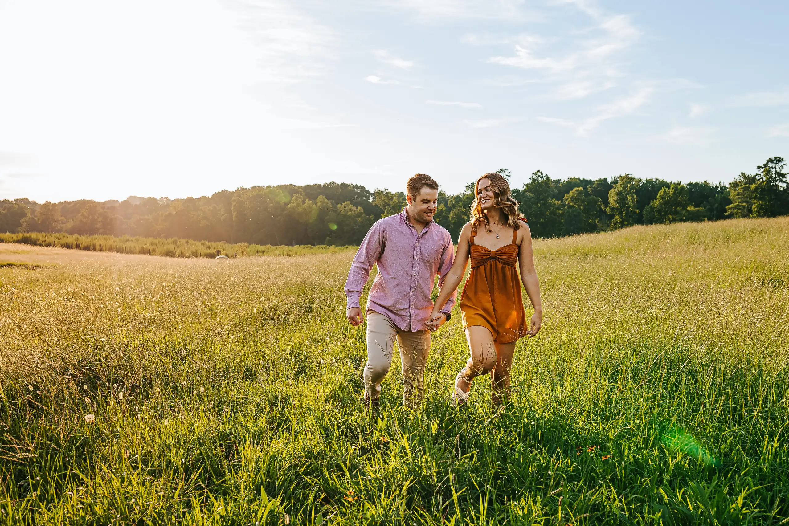 Engagement Portraits: the two of them walking the long grass together, during their engagement session at Prospect Farms in Lawrenceville, GA