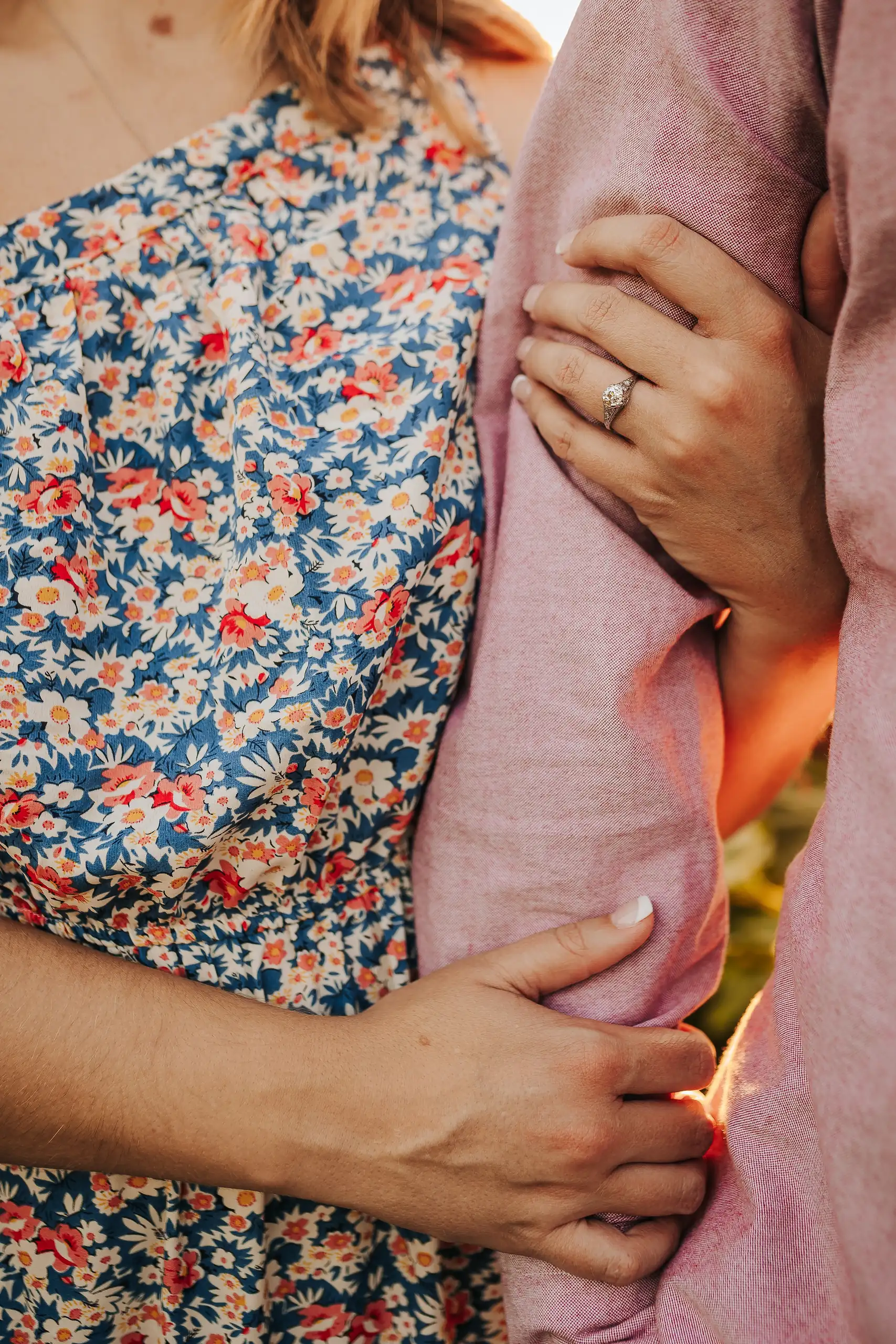 Engagement Portraits: his arms round her waist, her ring hand on his, during their engagement session at Prospect Farms in Lawrenceville, GA