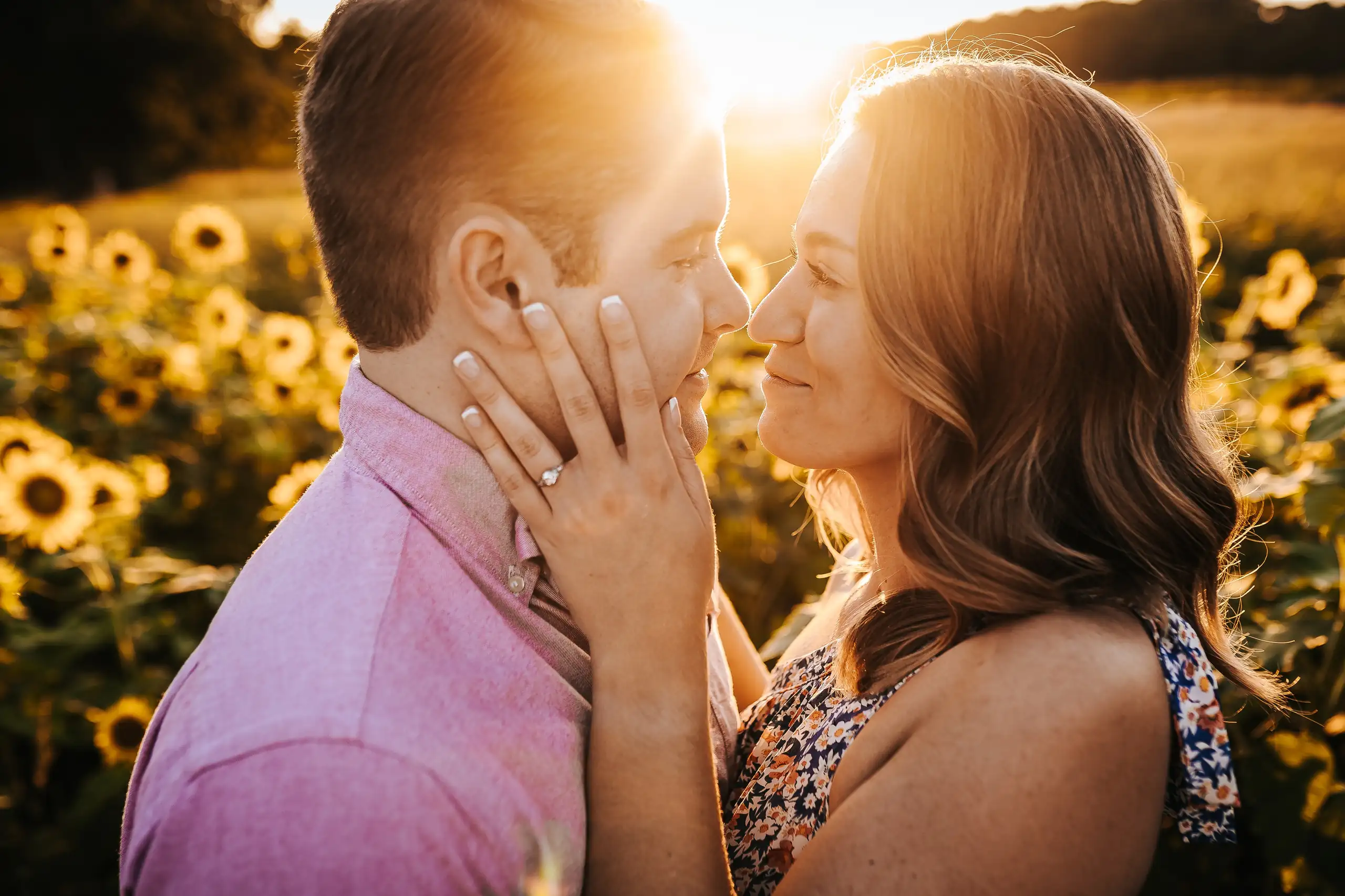 Engagement Portraits: her hands on his face, nose to nose in the flowers, during their engagement session at Prospect Farms in Lawrenceville, GA