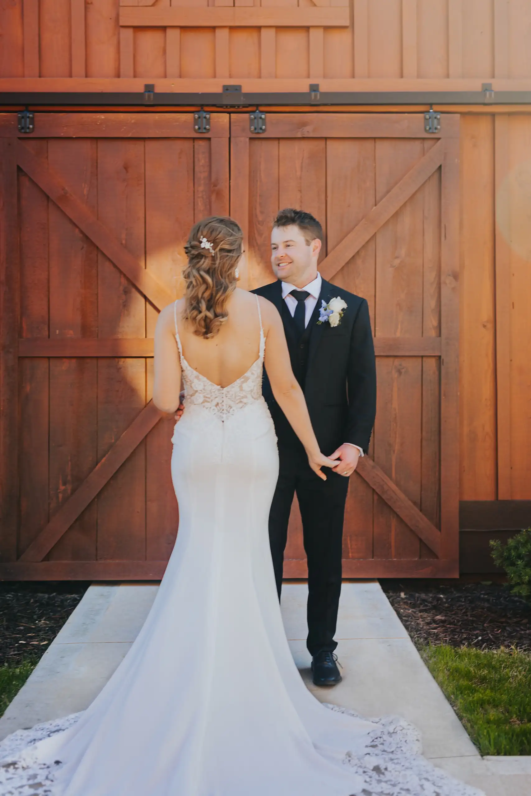 Wedding Formals: the couple at the barn doors, her train out, at their wedding at The Venue at Sharp Mountain in Jasper, GA
