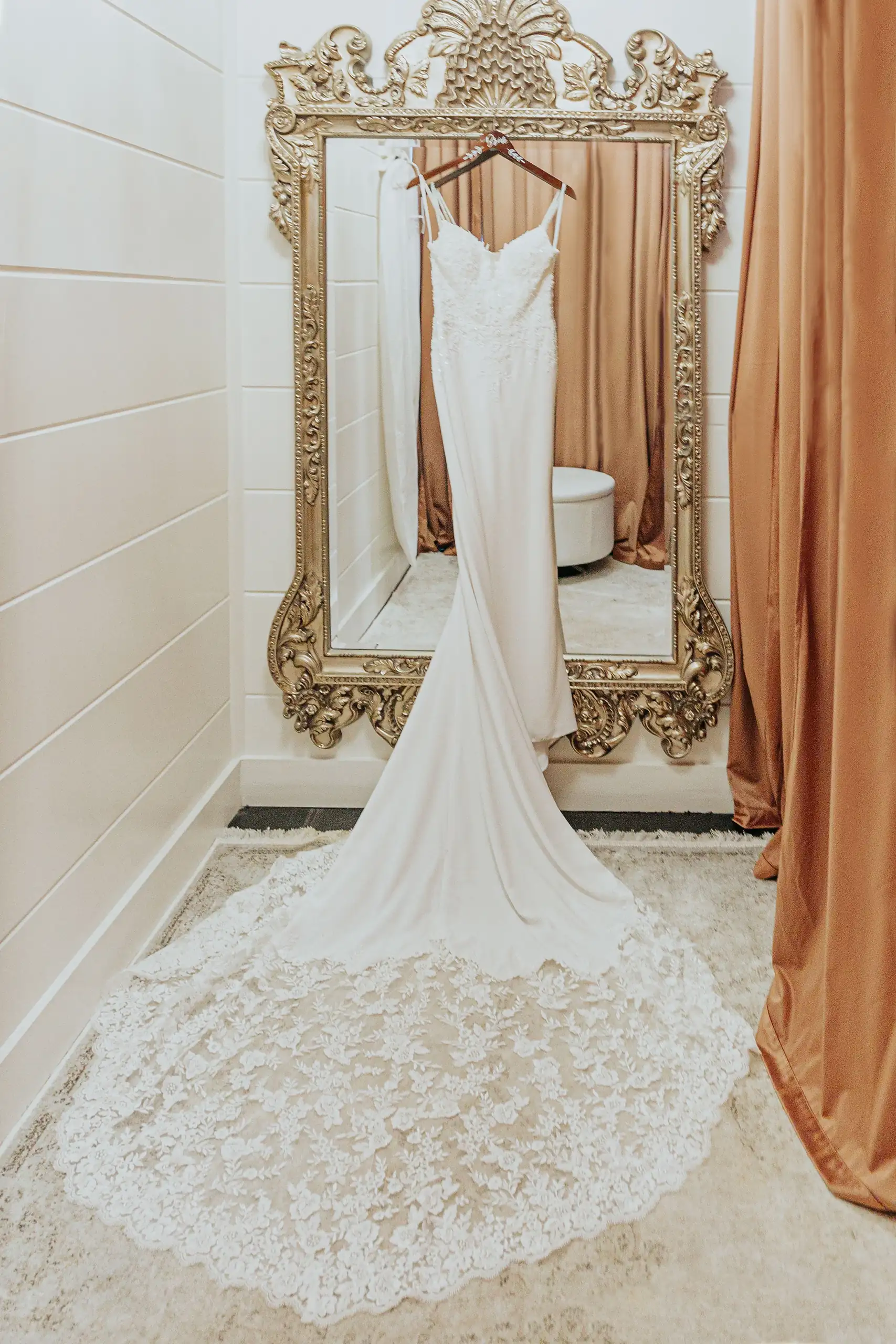 Wedding Details: the gown hanging in a gilt mirror frame, at a wedding at The Venue at Sharp Mountain in Jasper, GA