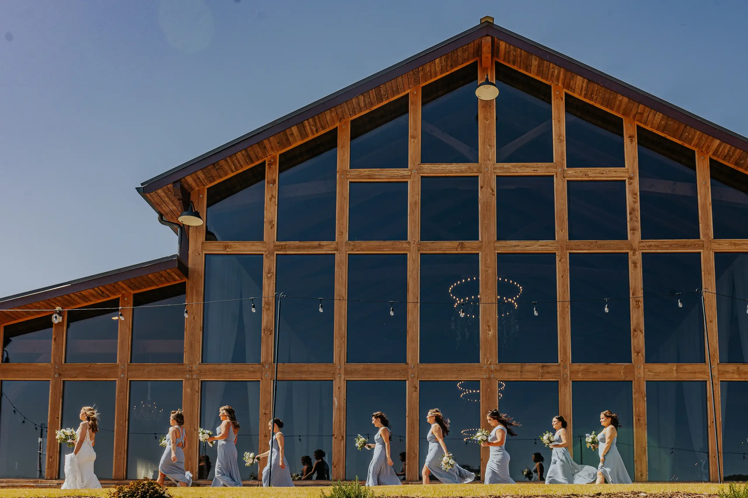 Wedding Ceremony: the timber and glass gable, the party reflected, at a wedding at The Venue at Sharp Mountain in Jasper, GA
