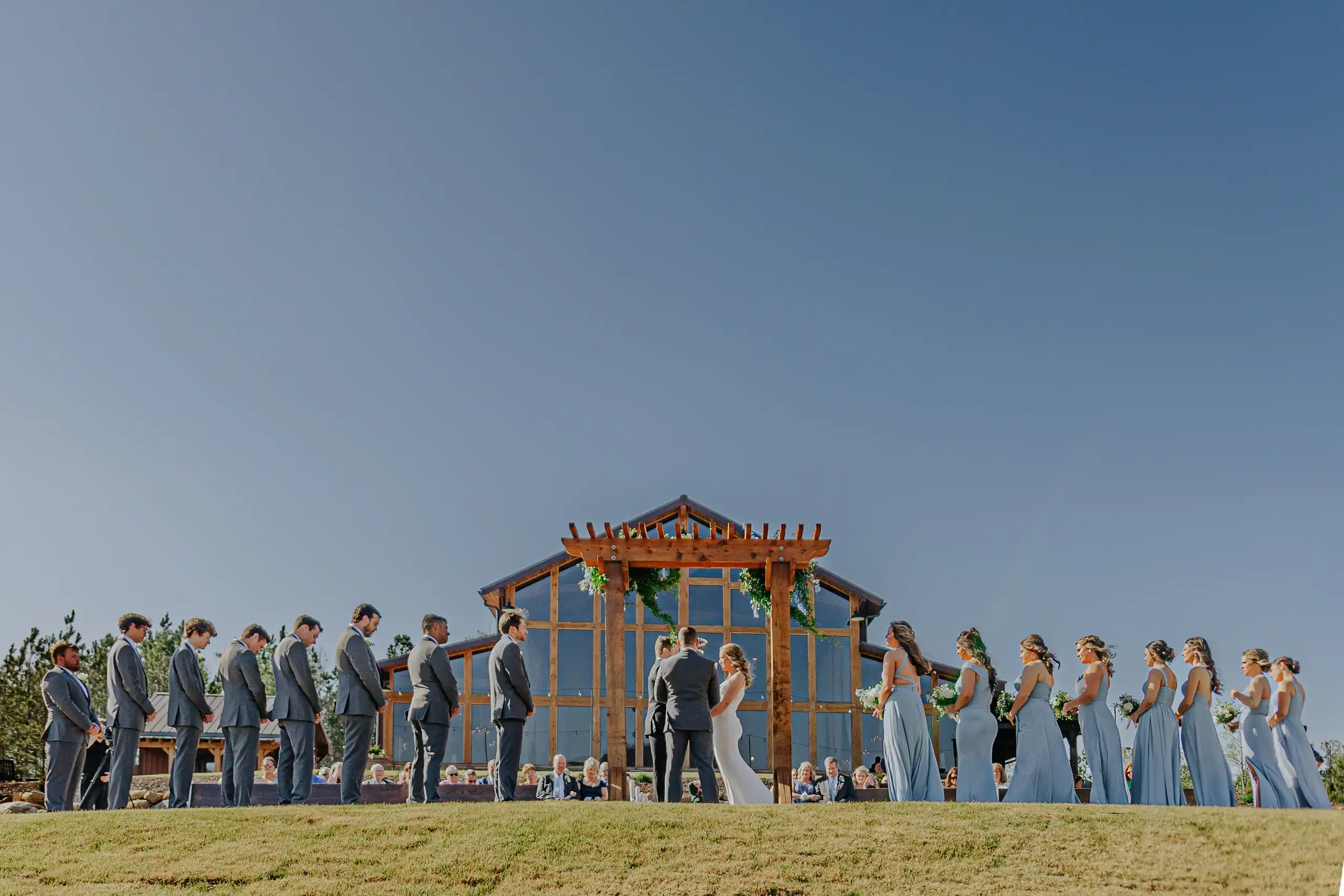 Wedding Ceremony: the ceremony at the timber arch below the mountains, at their wedding at The Venue at Sharp Mountain in Jasper, GA