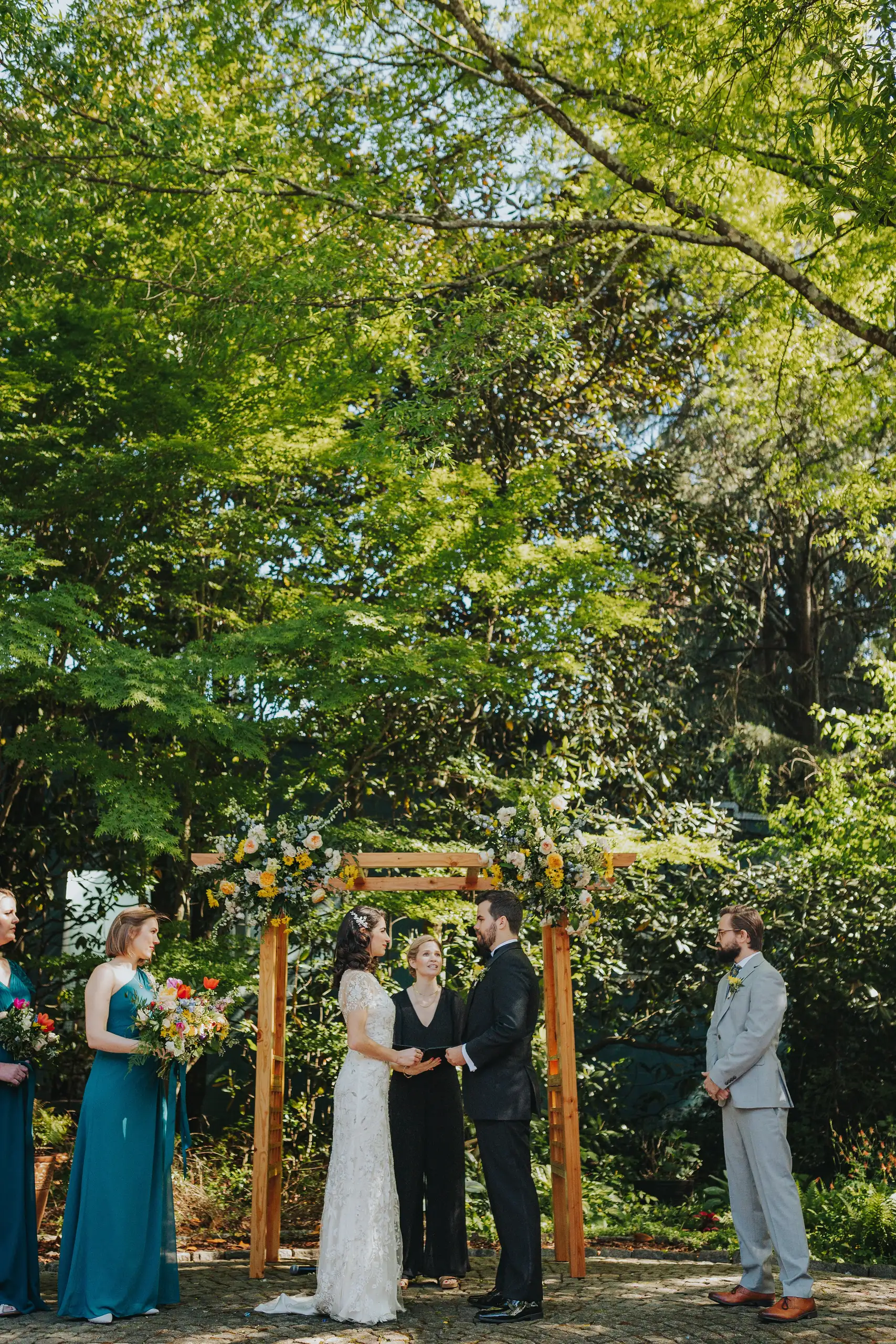 Wedding Ceremony: the couple saying their vows beneath the arch, at their wedding at the Trolley Barn in Atlanta, GA