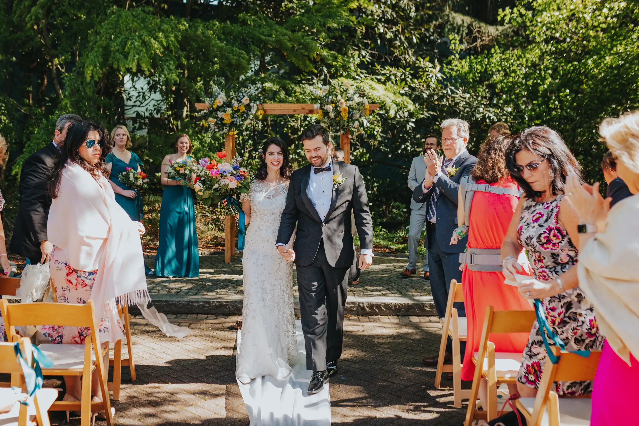 Recessional: the couple coming back up the aisle through petals, at their wedding at the Trolley Barn in Atlanta, GA