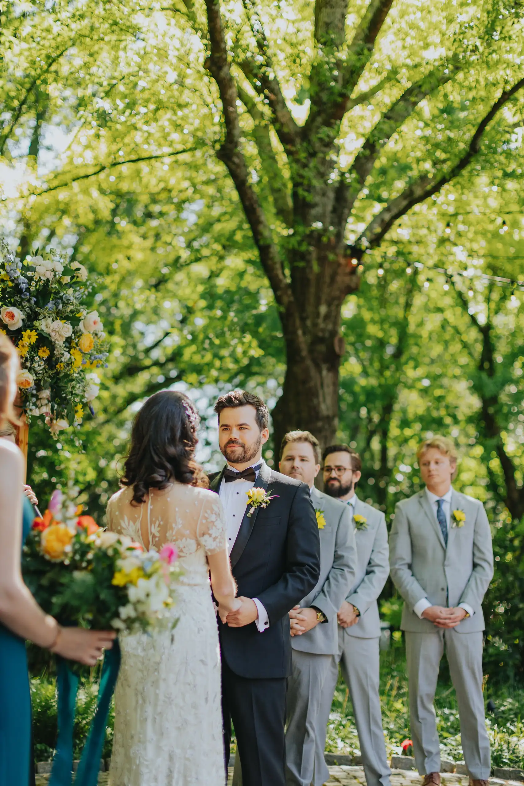 Wedding Ceremony: the couple at the front with the groomsmen, at their wedding at the Trolley Barn in Atlanta, GA