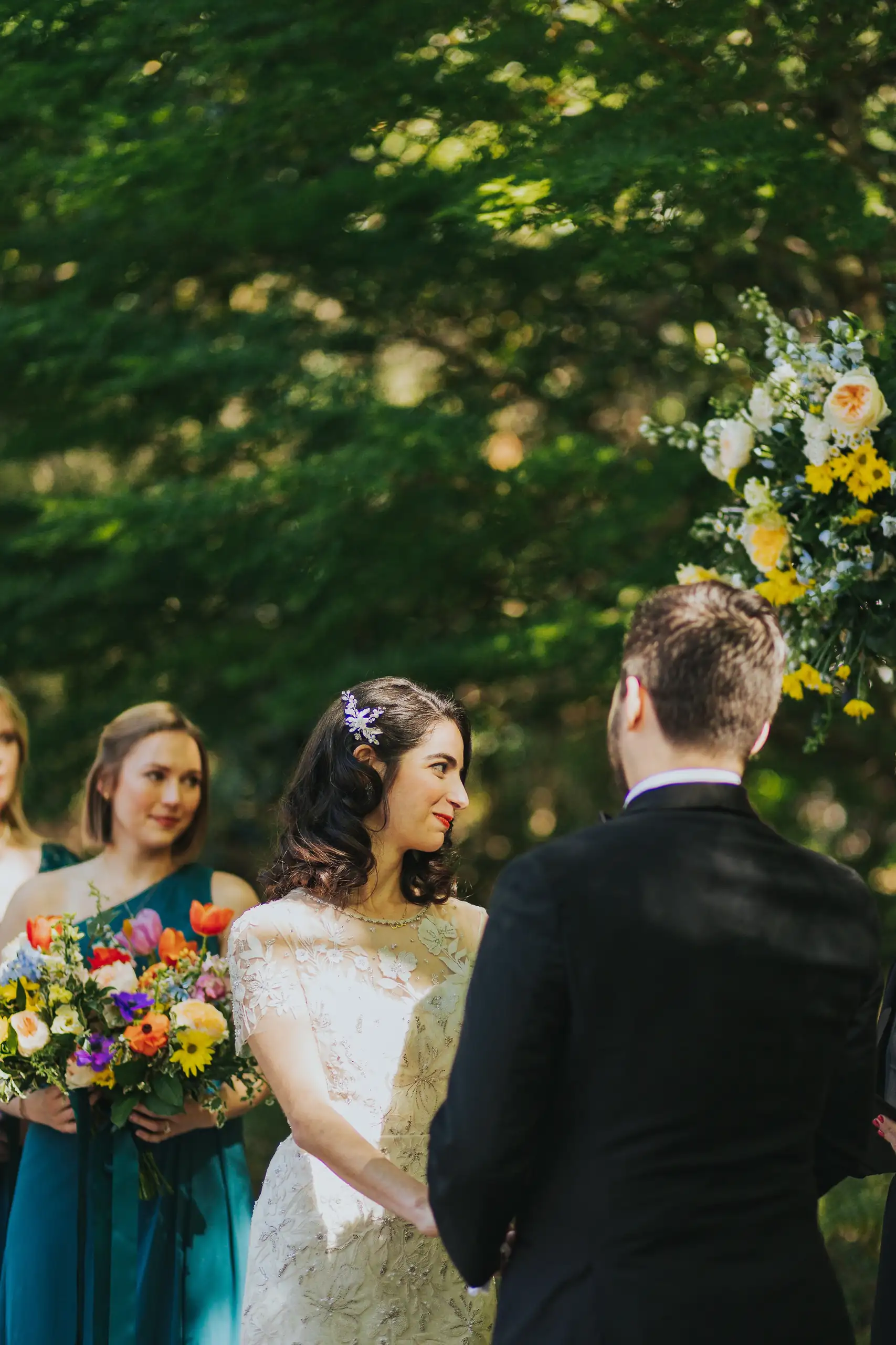 Wedding Ceremony: the couple at the arch with the officiant, at their wedding at the Trolley Barn in Atlanta, GA