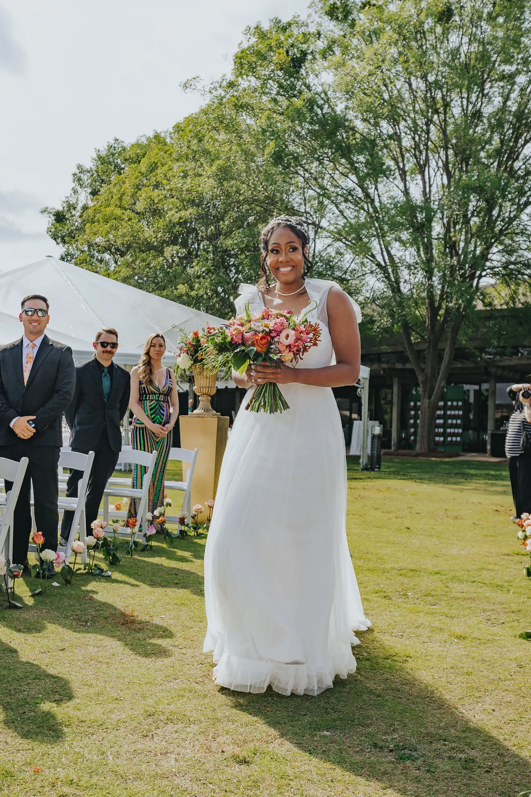 Processional: the bride coming up the aisle with her bouquet, at their wedding at Callaway Gardens in Pine Mountain, GA