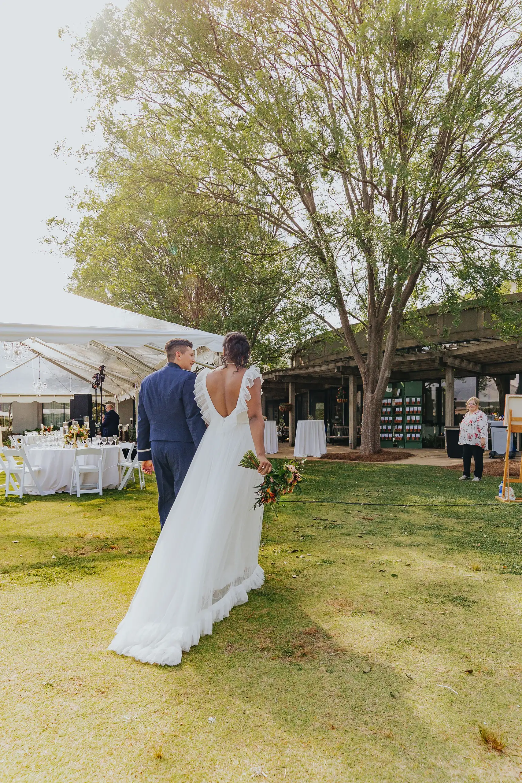 Bridal Portraits: the bride alone on the grass outside the tent, at their wedding at Callaway Gardens in Pine Mountain, GA