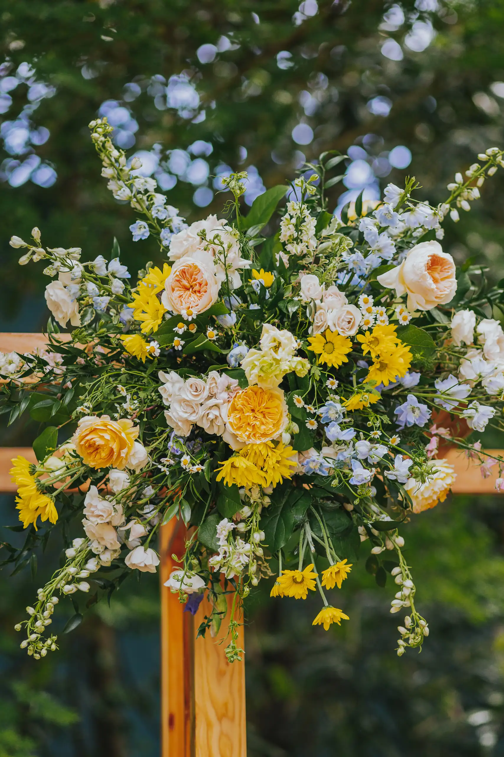 Wedding Florals: yellow and blue flowers tied to a wooden post, at a wedding at the Trolley Barn in Atlanta, GA