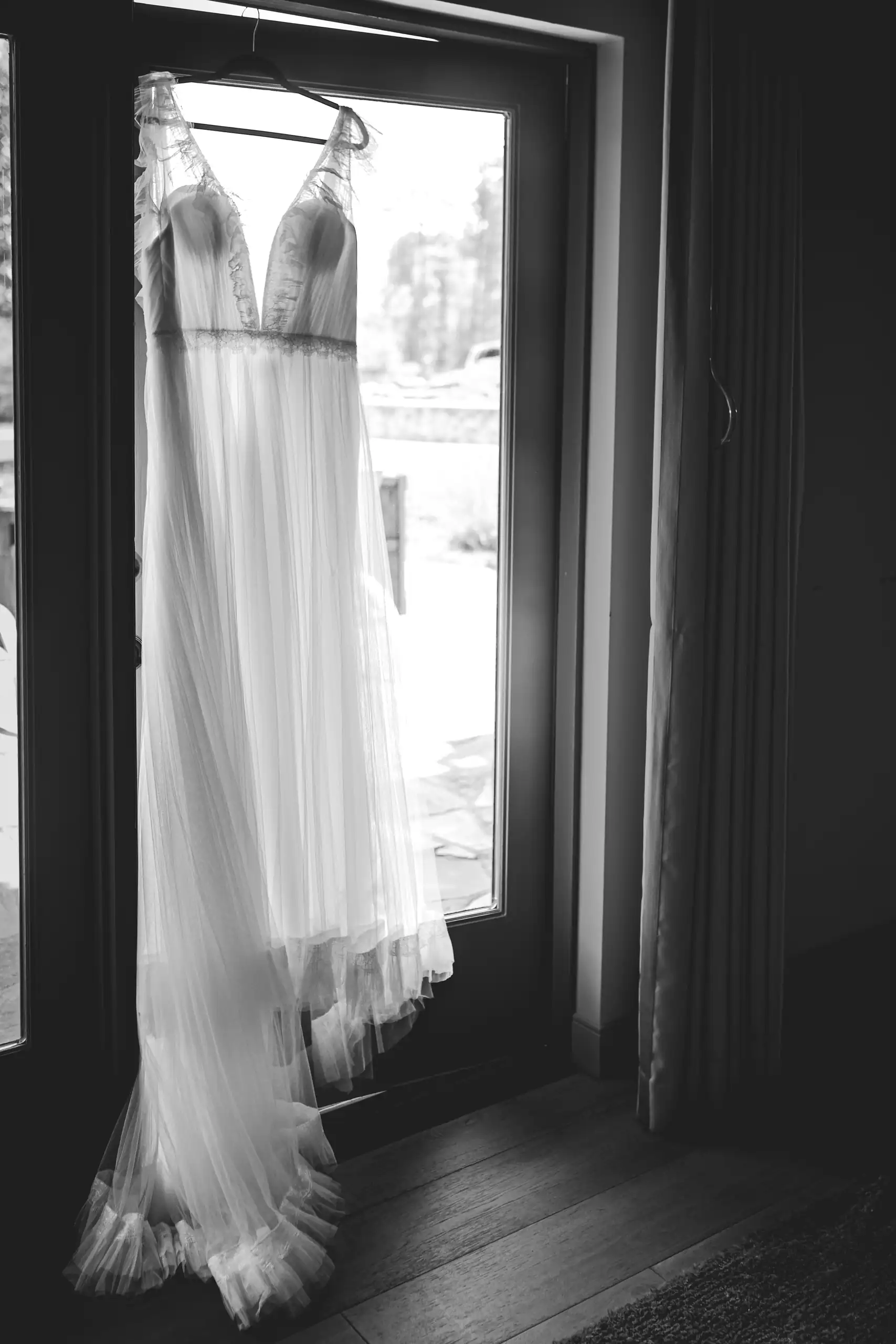 Wedding Details: the gown hanging in the doorway, in black and white, at a wedding at Callaway Gardens in Pine Mountain, GA