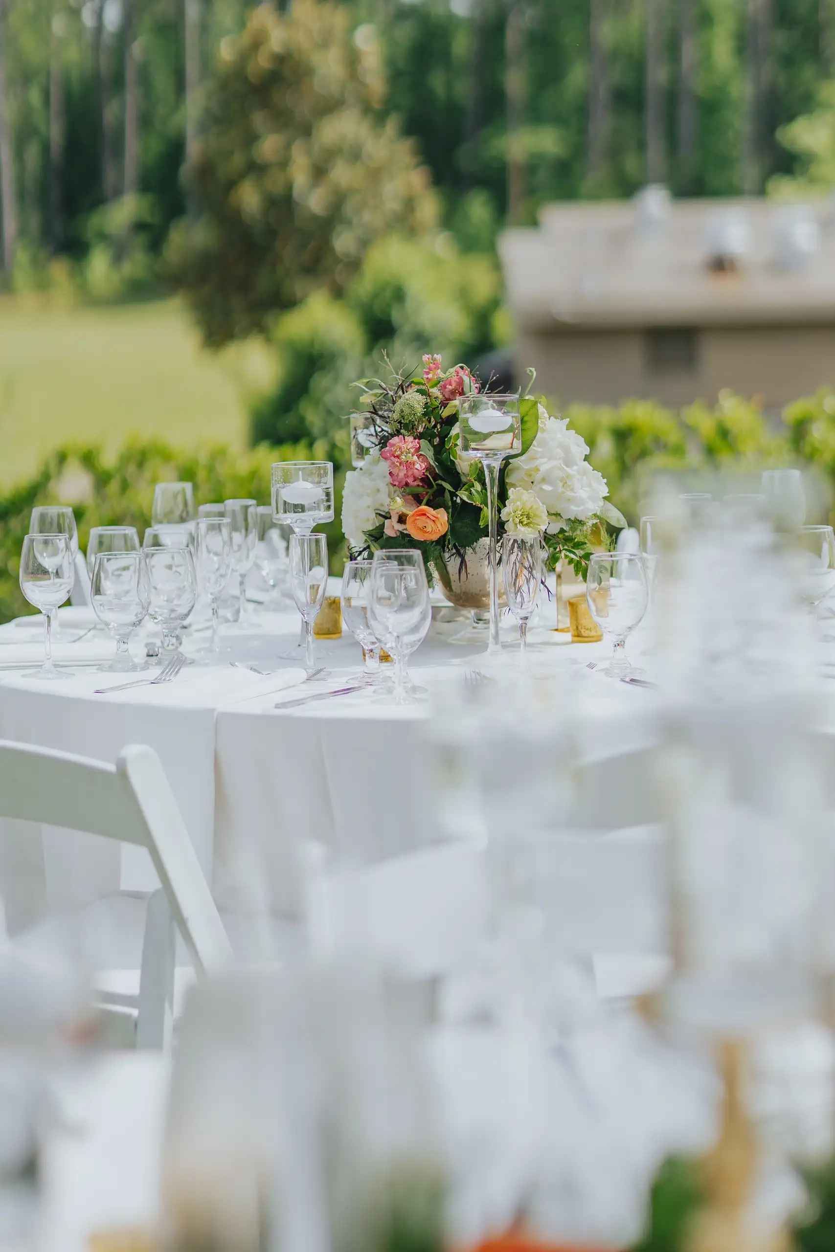 Reception Details: a round table laid with glassware and low florals, at a wedding at Callaway Gardens in Pine Mountain, GA