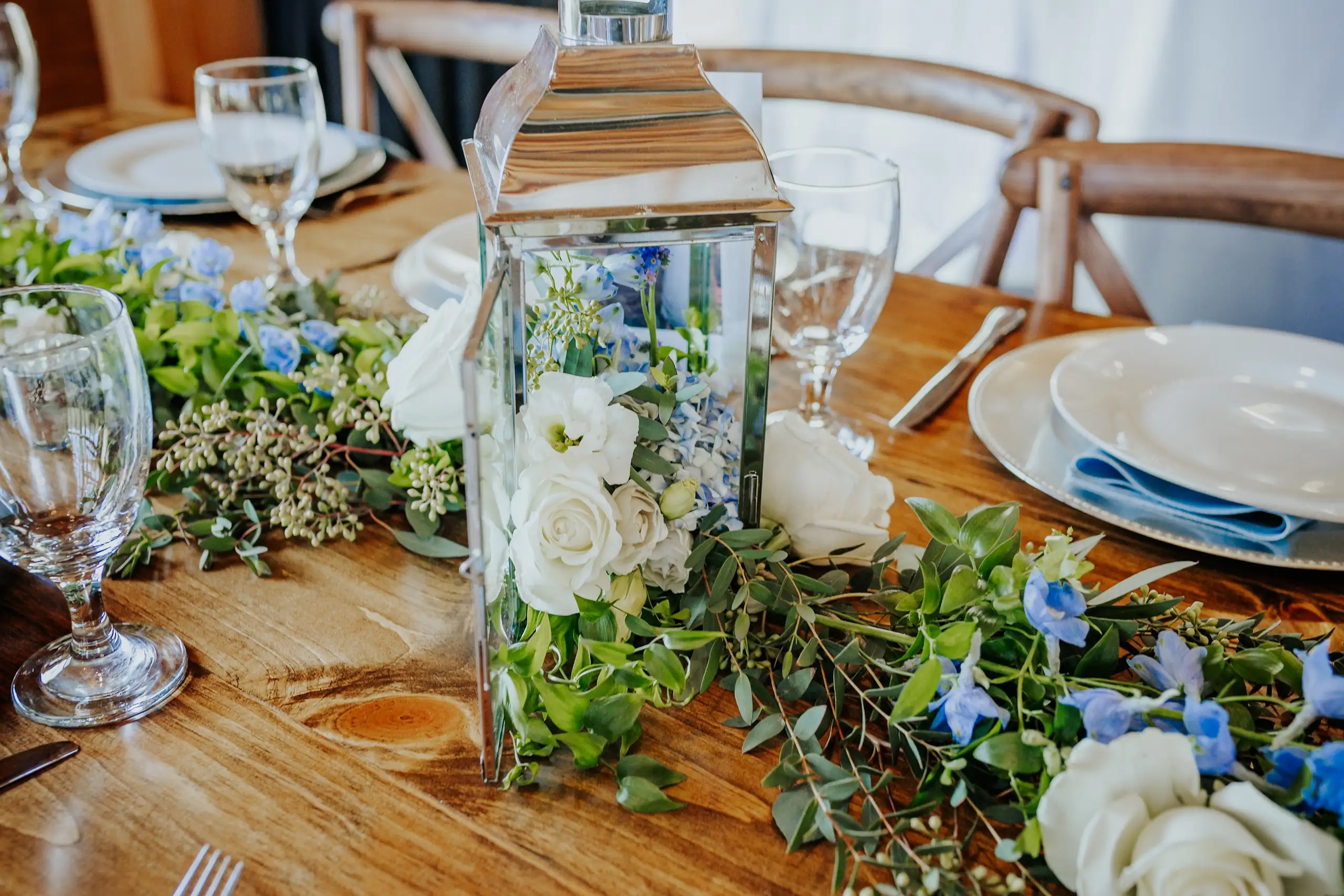Reception Details: the table with its greenery runner and lanterns, at their wedding at The Venue at Sharp Mountain in Jasper, GA