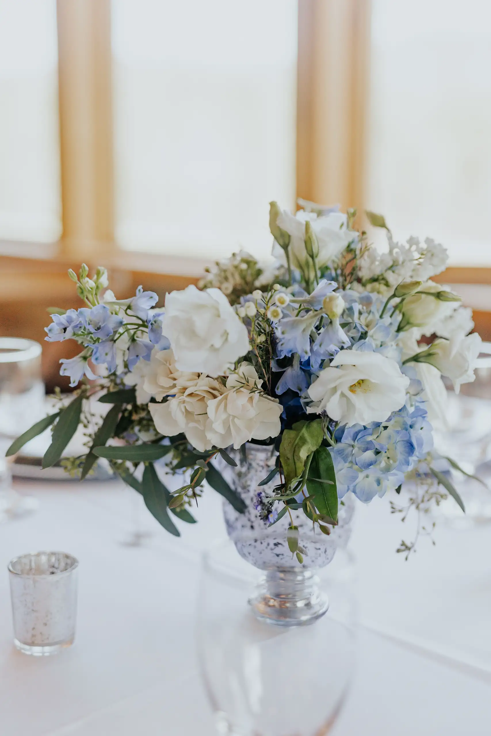 Wedding Florals: a blue and white centerpiece in a footed bowl, at their wedding at The Venue at Sharp Mountain in Jasper, GA