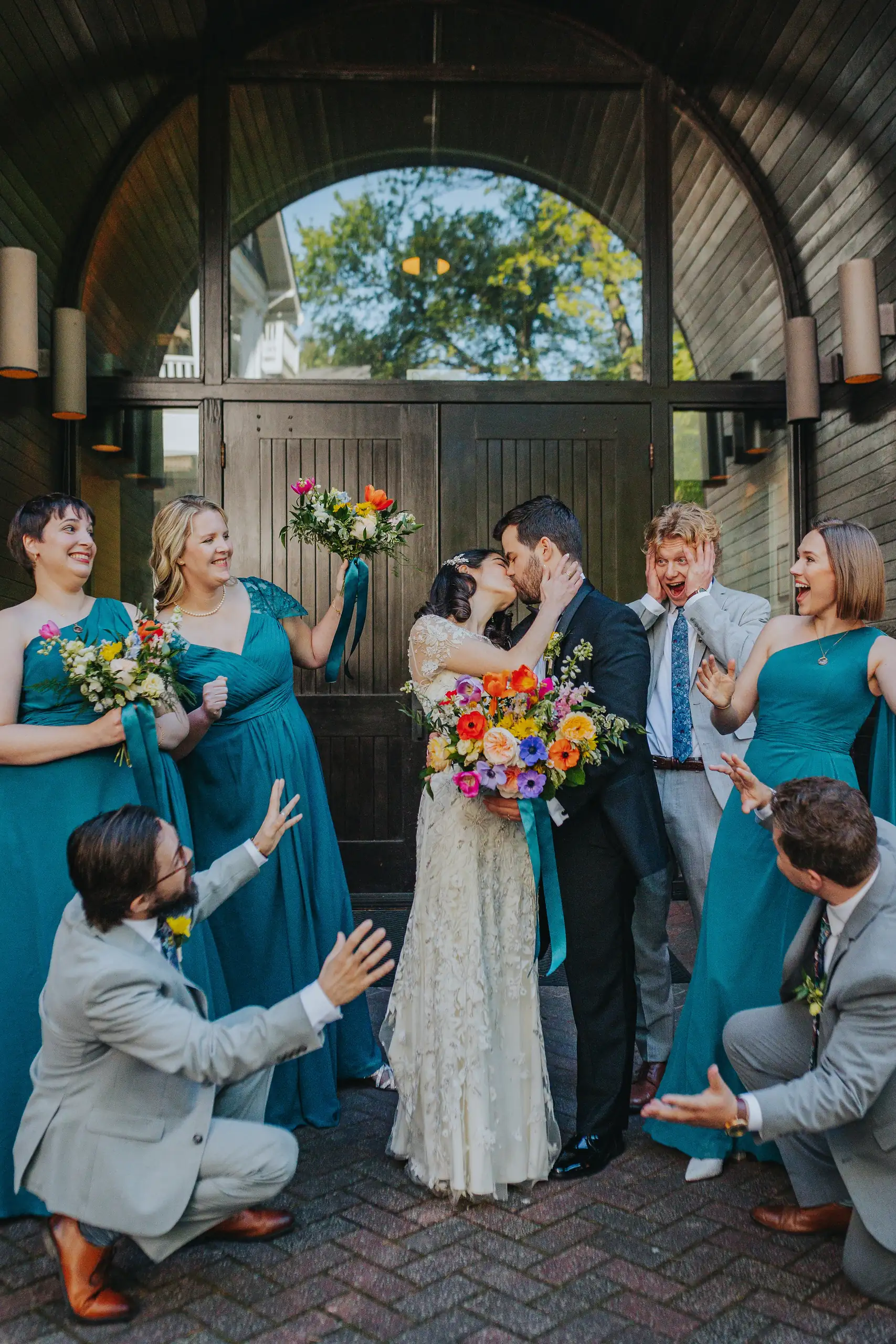 Wedding Party: the bridal party cheering as the couple kiss, at their wedding at the Trolley Barn in Atlanta, GA