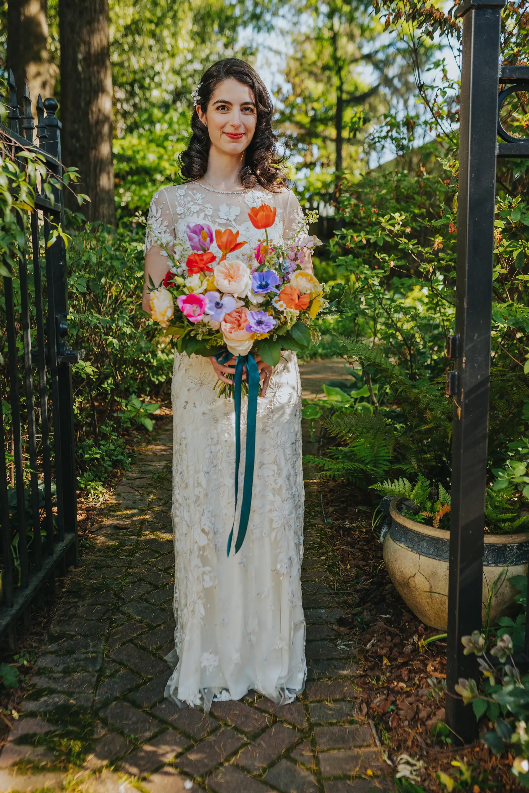 Bridal Portraits: the bride and her bright bouquet on the garden path, at their wedding at the Trolley Barn in Atlanta, GA